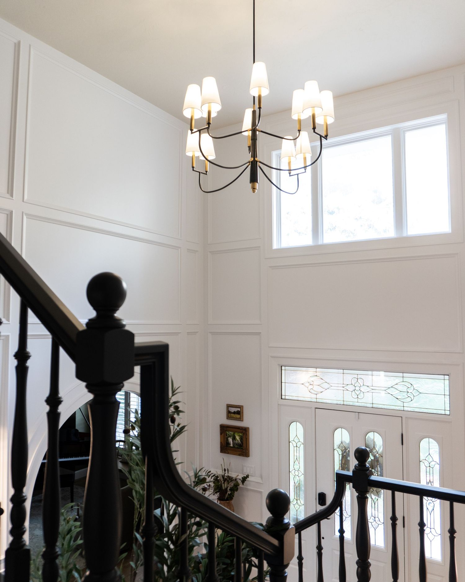 Detail on a high ceiling entry way to custom wall treatments with a beautiful chandelier