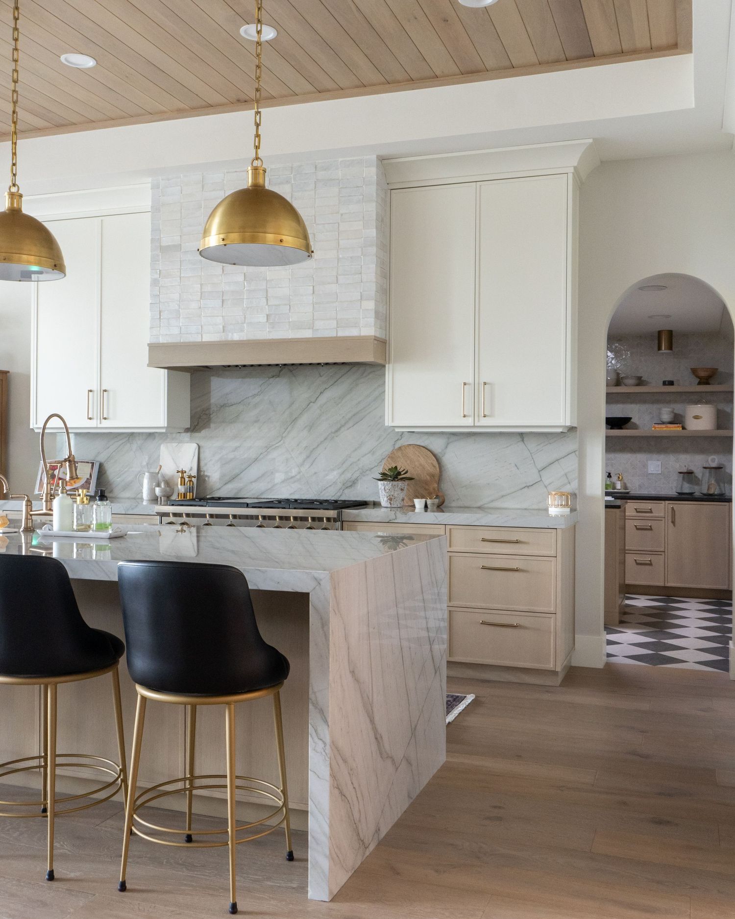 Custom addition kitchen in Riverton Utah with waterfall island counertop and white oak panel ceiling detail.