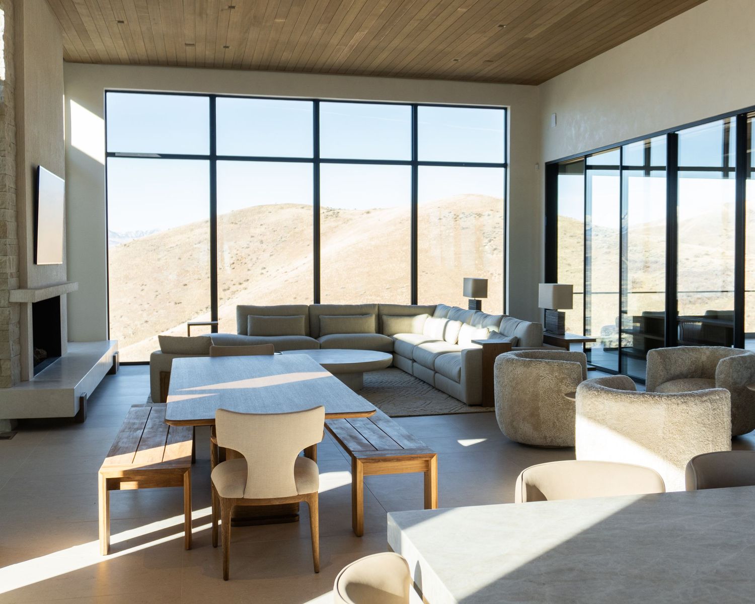 Custom built Lehi Utah home with floor to ceiling windows allowing sun to shine on the modern, beige living room.