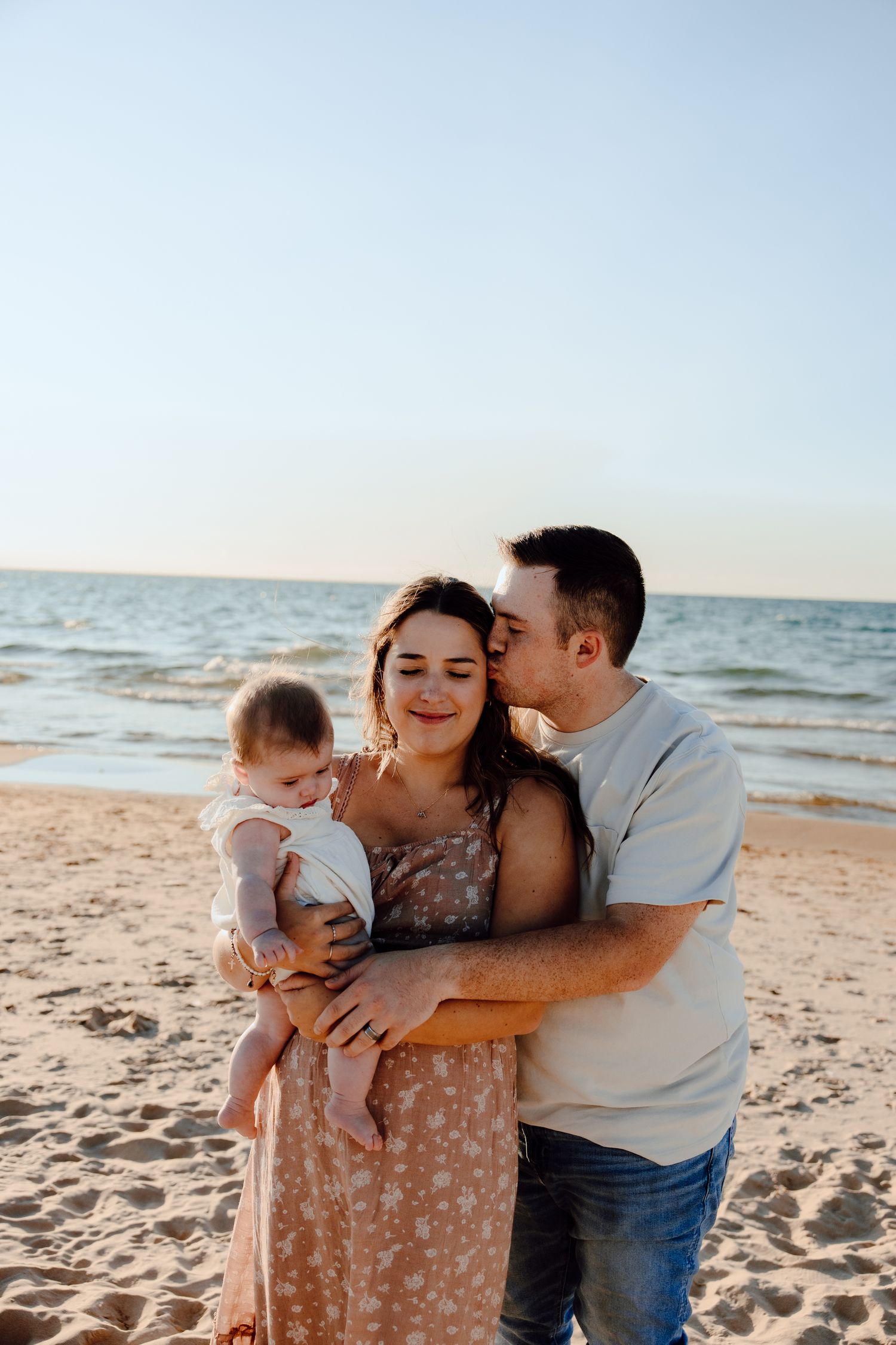 Intimate family moment captured during sunset beach photoshoot.