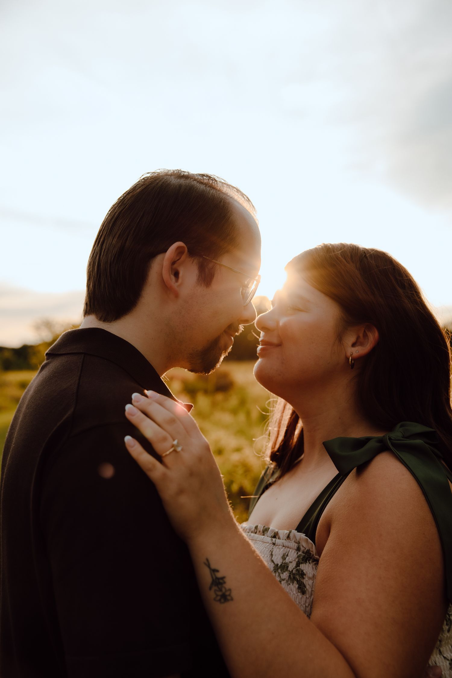 Intimate couple portrait silhouetted against golden sunset light.