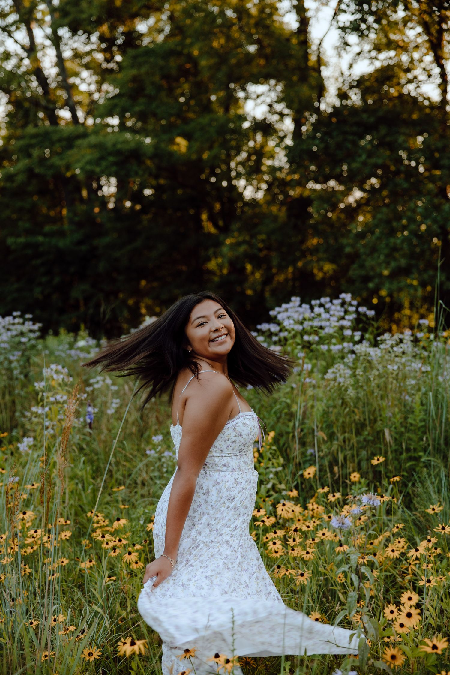 Joyful movement captured in a white dress among yellow wildflowers at sunset.