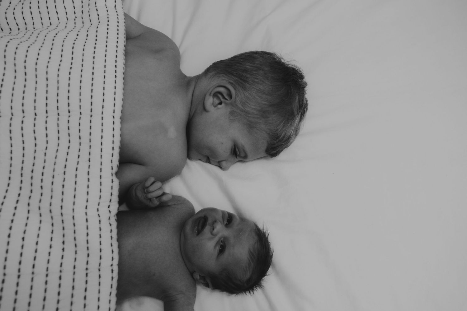 Peaceful sleeping scene with knitted blanket detail in monochrome.
