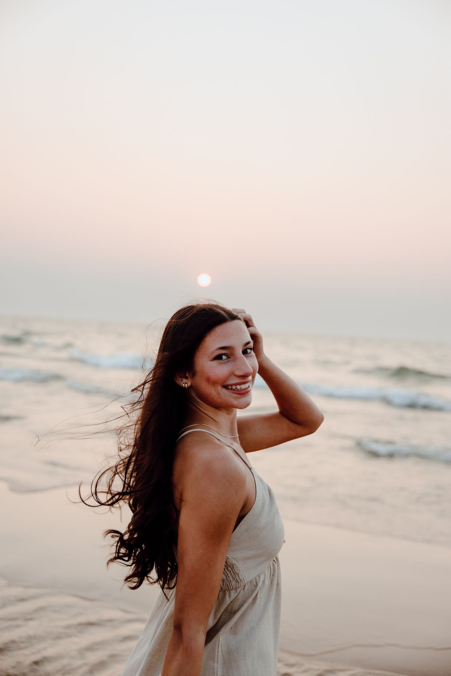 Joyful beachside portrait session during golden hour with ocean waves.