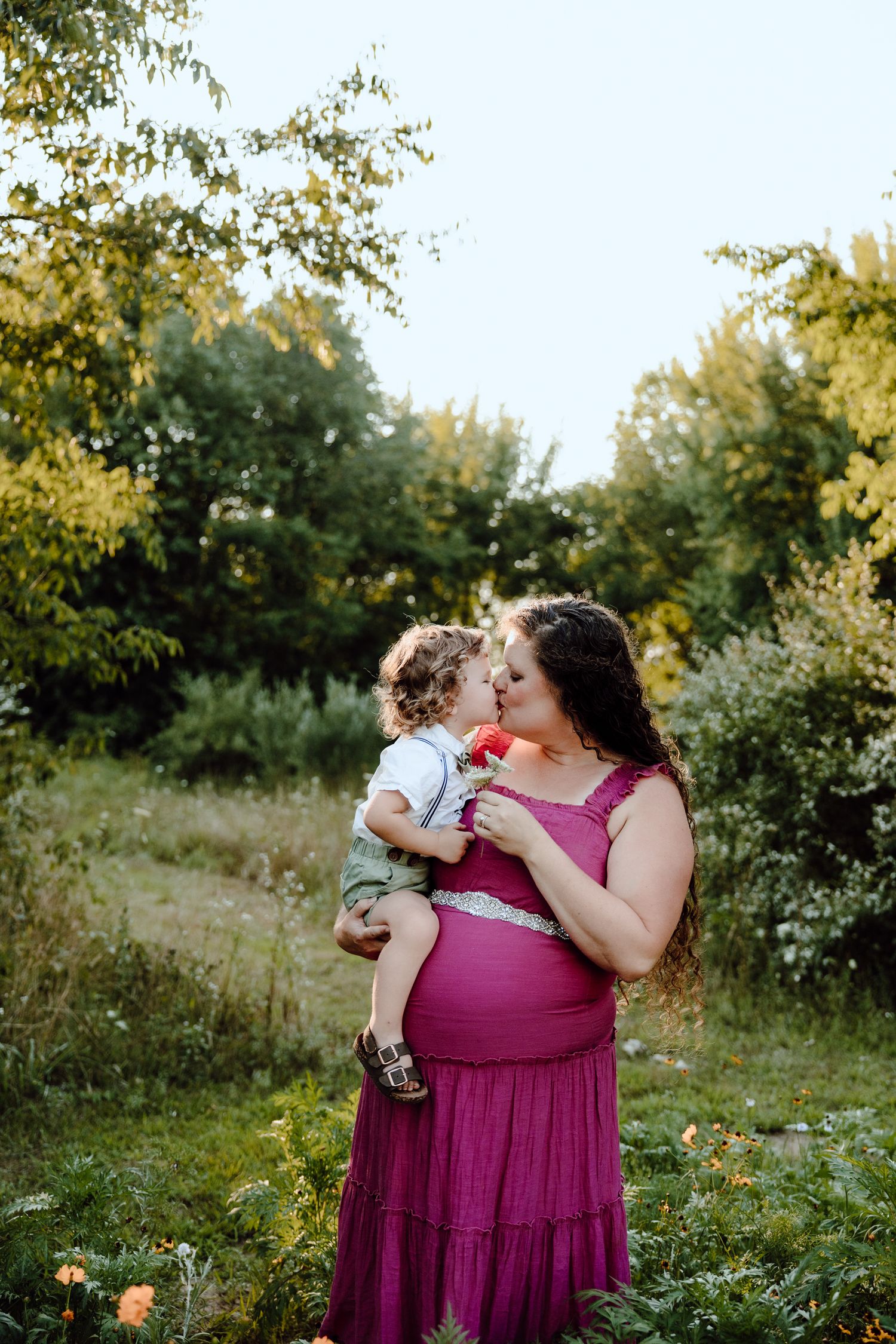 A tender moment captured in a lush garden setting during summer.