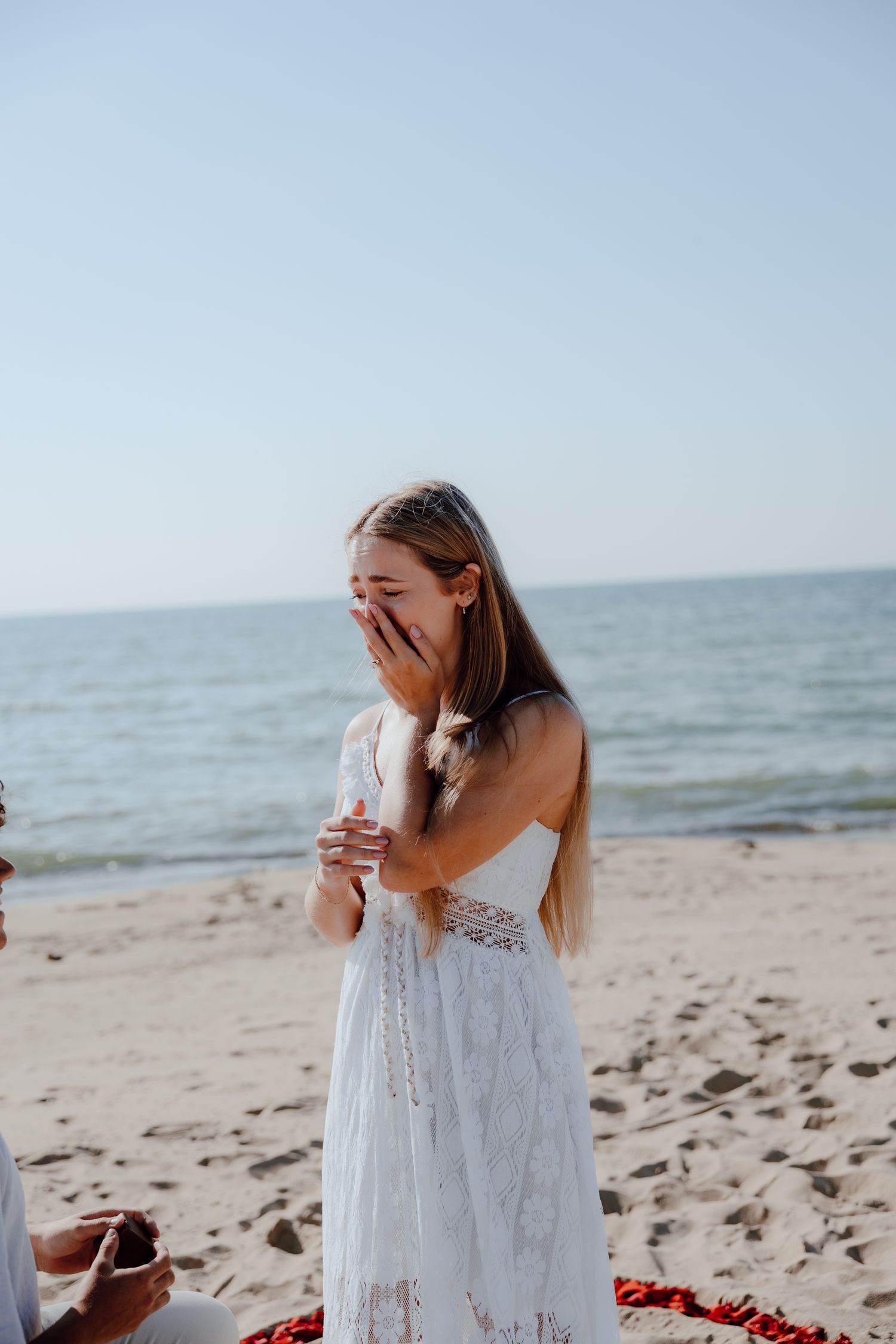 A romantic beach scene with a flowing white dress against the ocean backdrop.