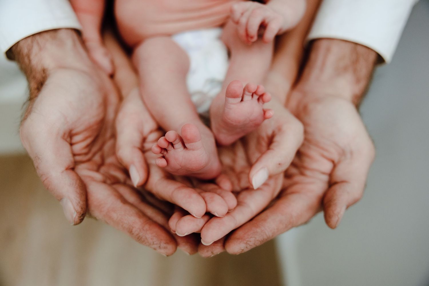 Multiple hands coming together in a caring gesture against white background.