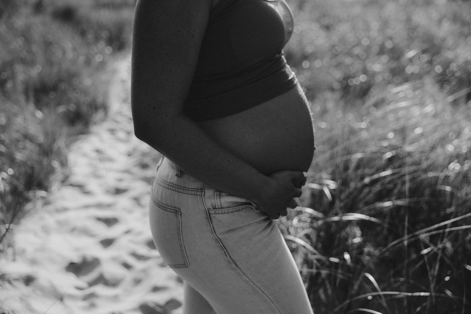 Black and white maternity photo series showing couple embracing.