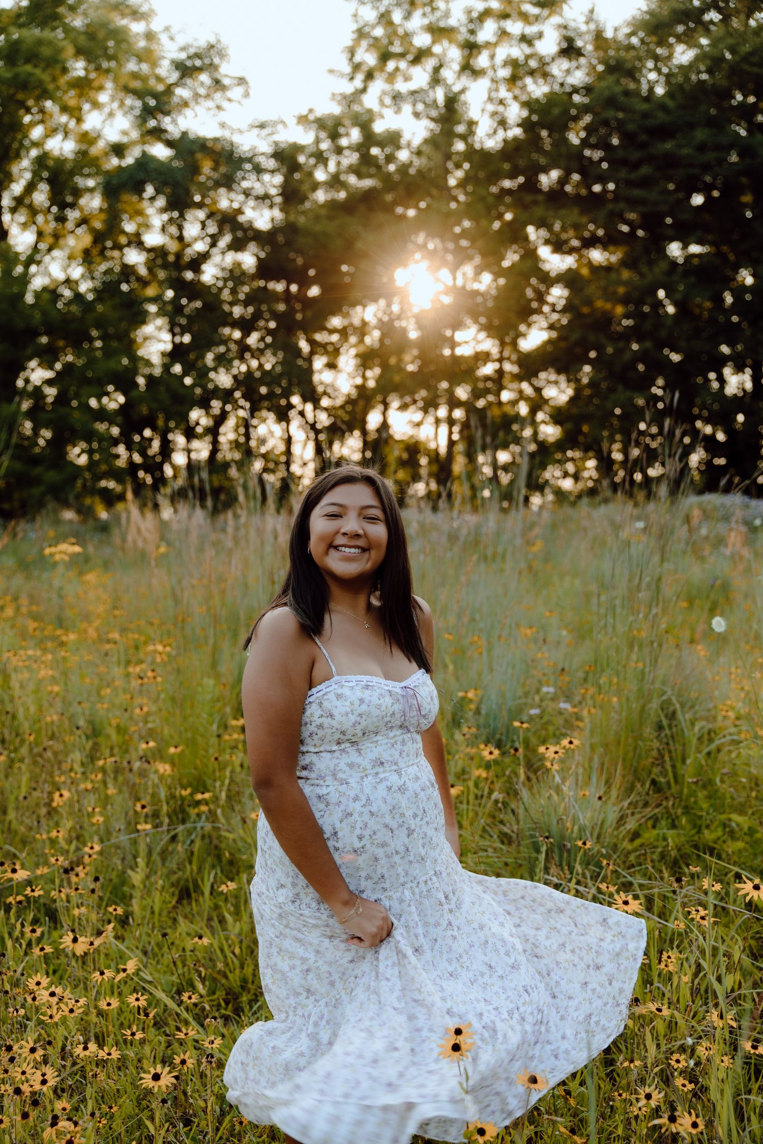 Playful summer photoshoot in a white dress among wildflowers at golden hour.