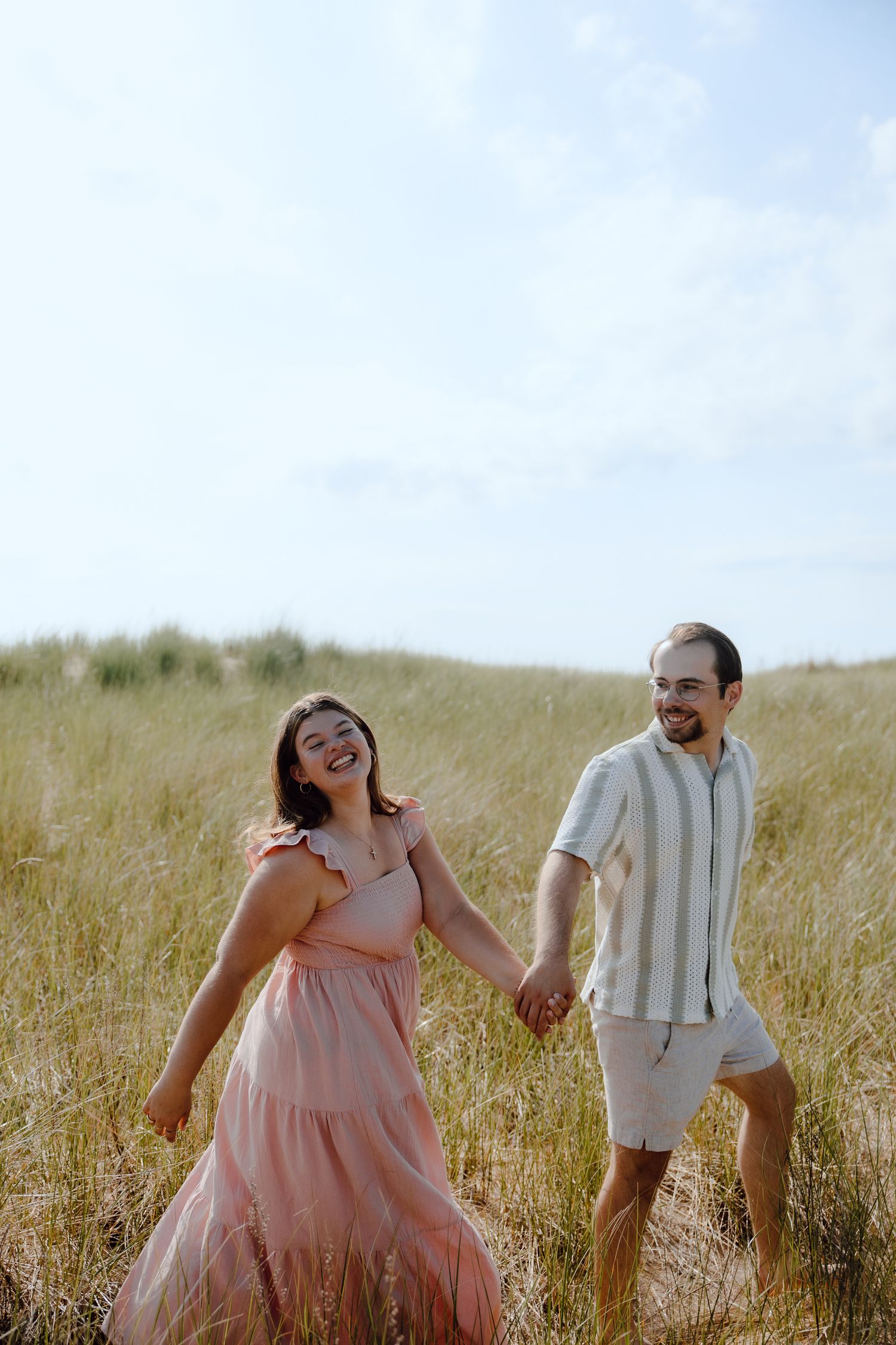 A candid moment of laughter and joy in a seaside field.