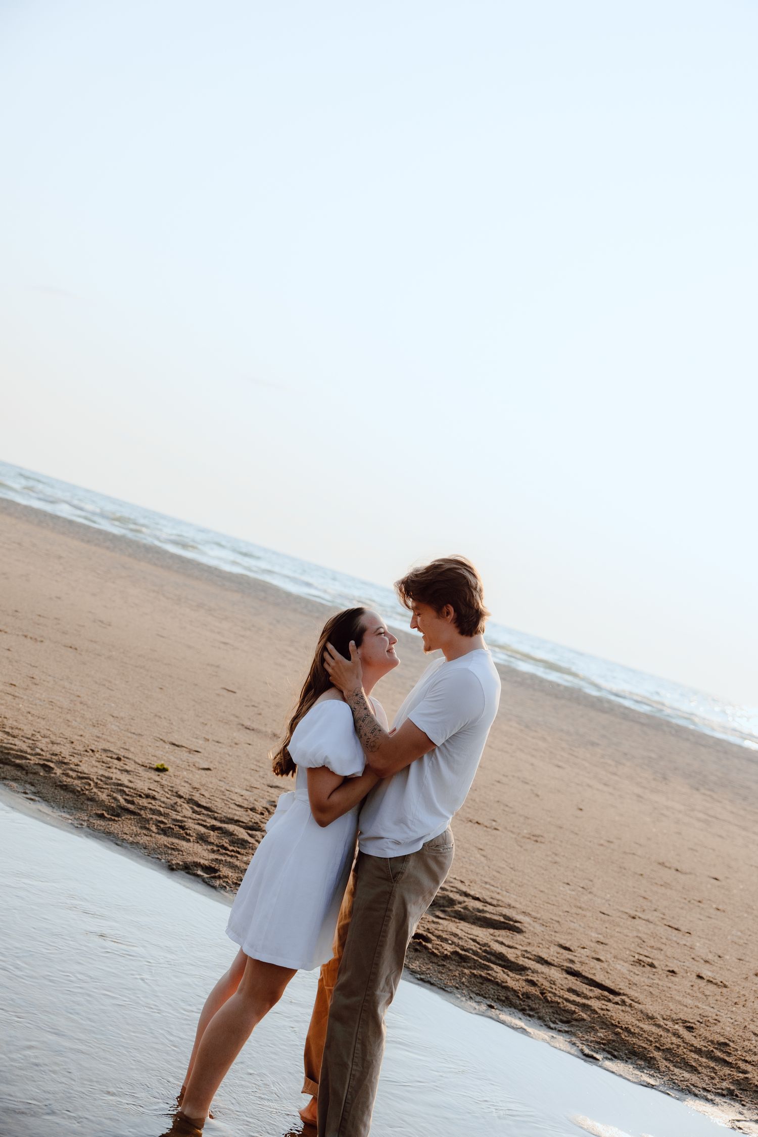A tender moment captured on a sandy beach at sunset.