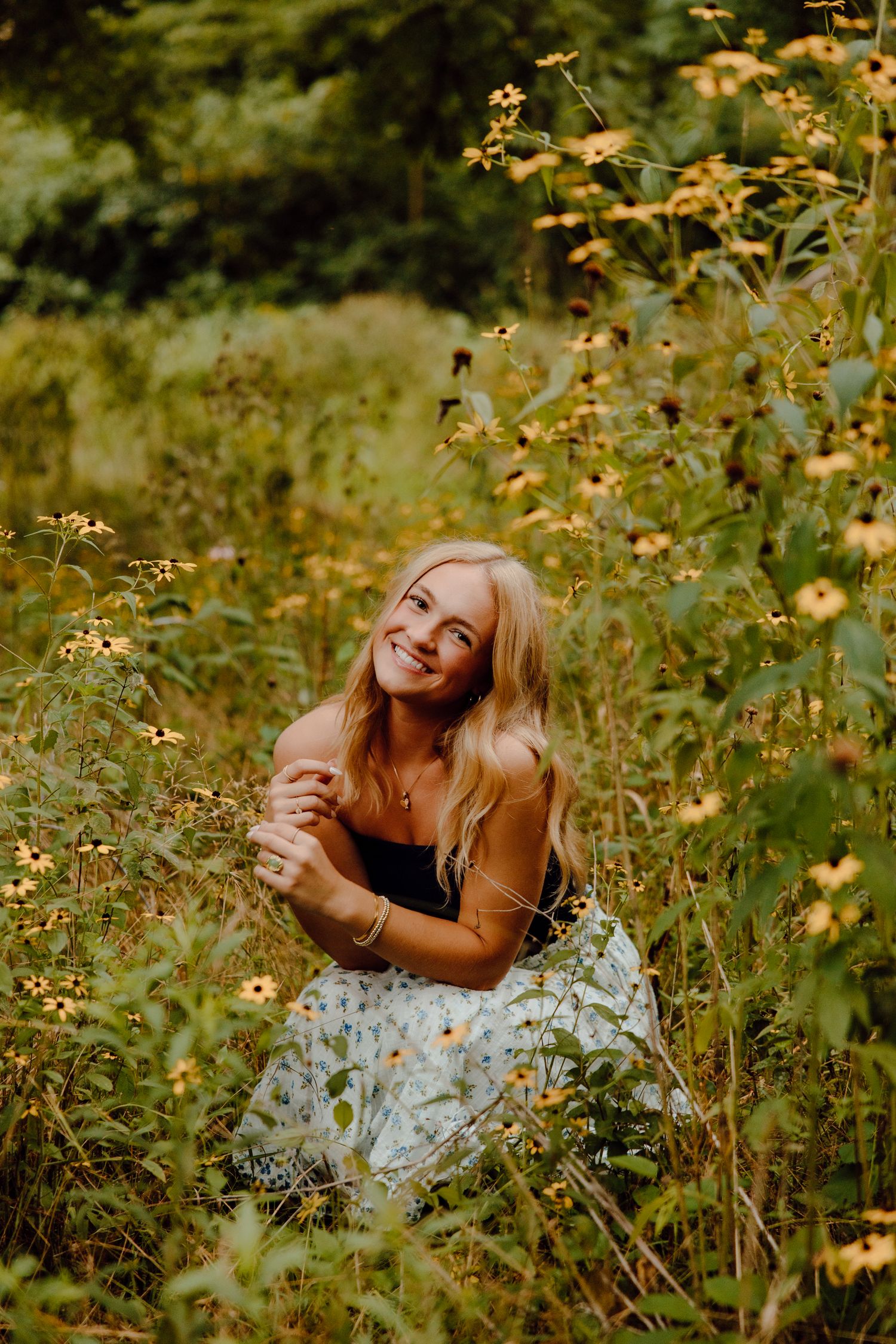 Joyful outdoor portrait among golden wildflowers on a warm summer evening.