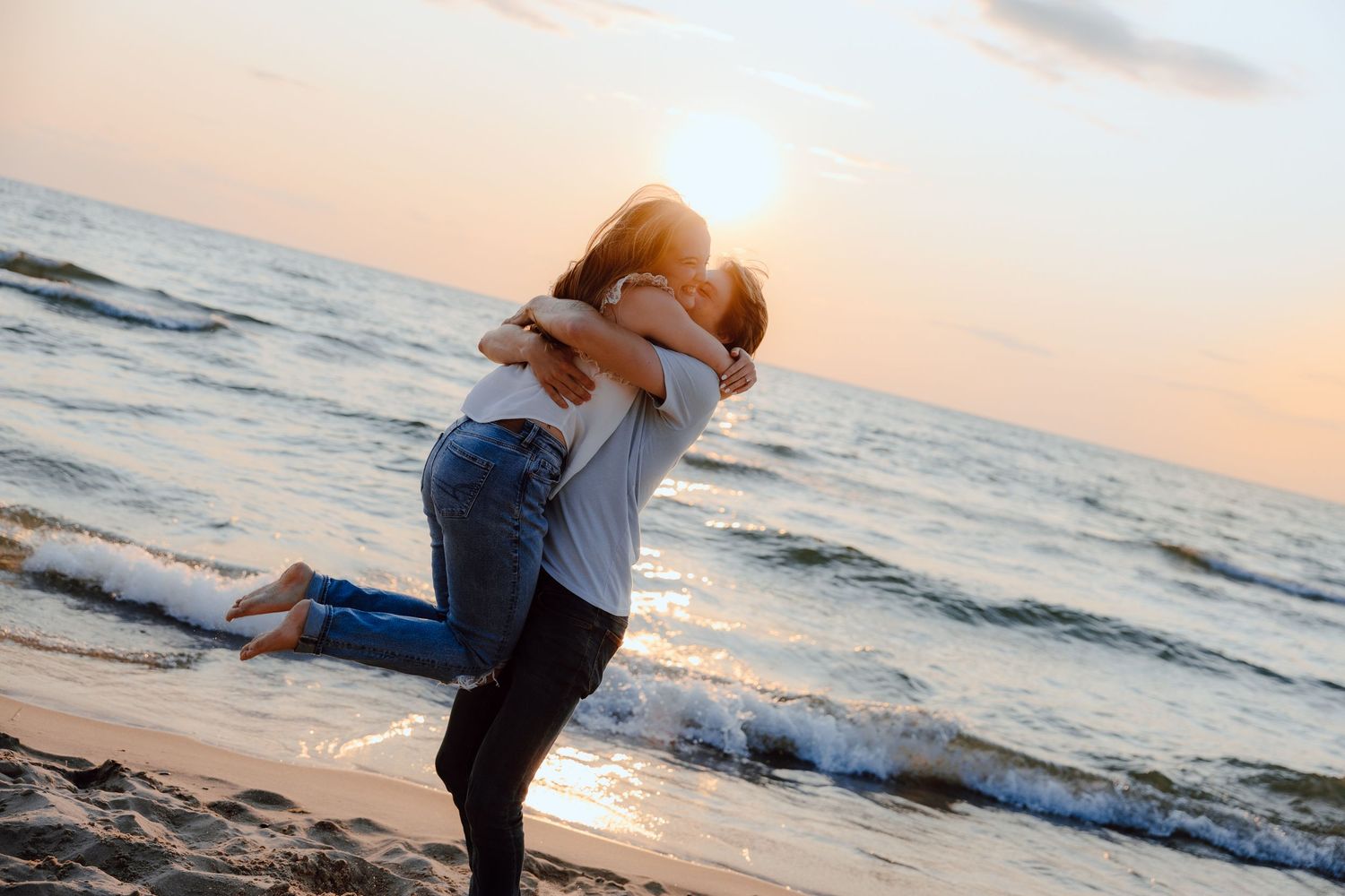 A playful beach scene with waves crashing in the background at sunset.