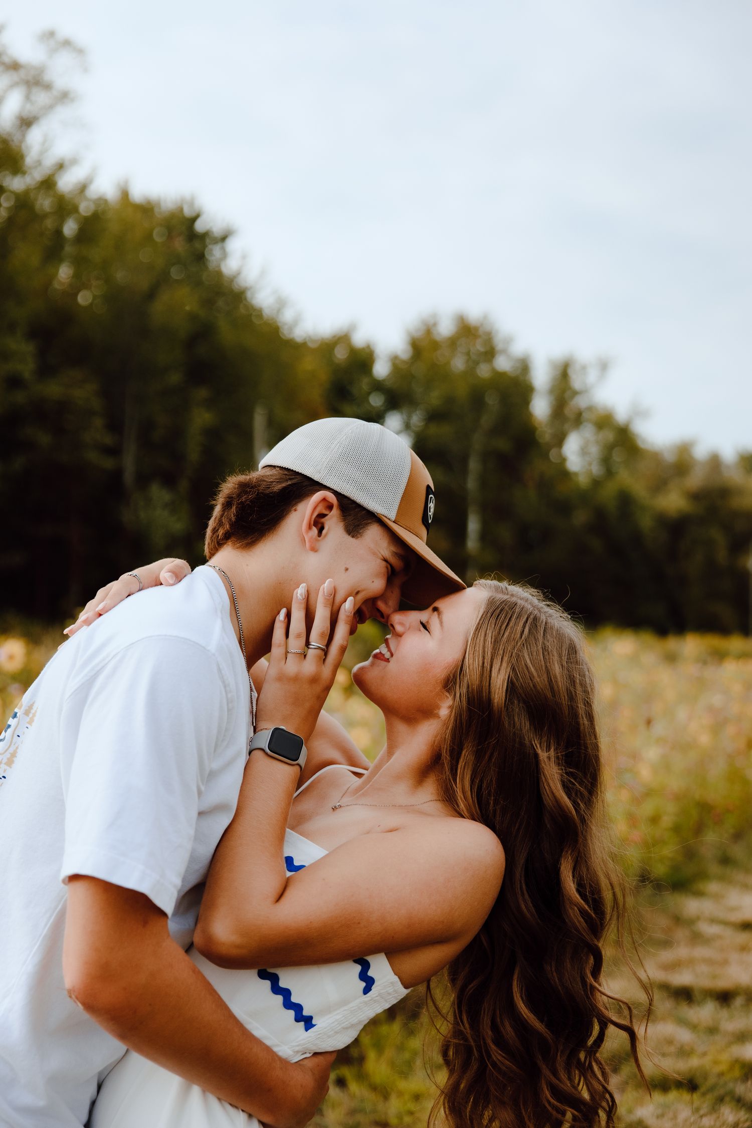 A tender moment captured between two people in a sunlit meadow.