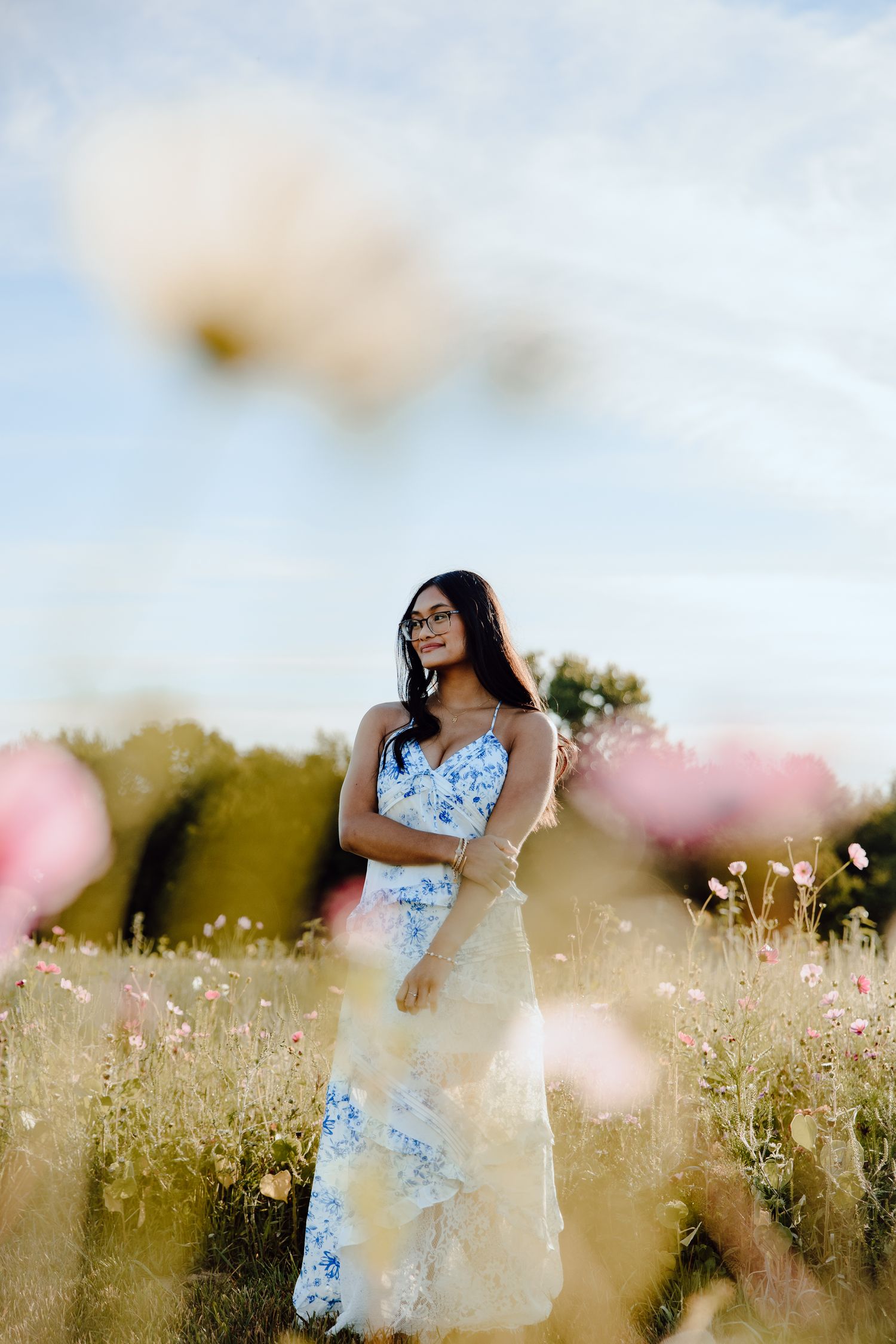 Dreamy summer portrait in a field of delicate wildflowers under soft light.