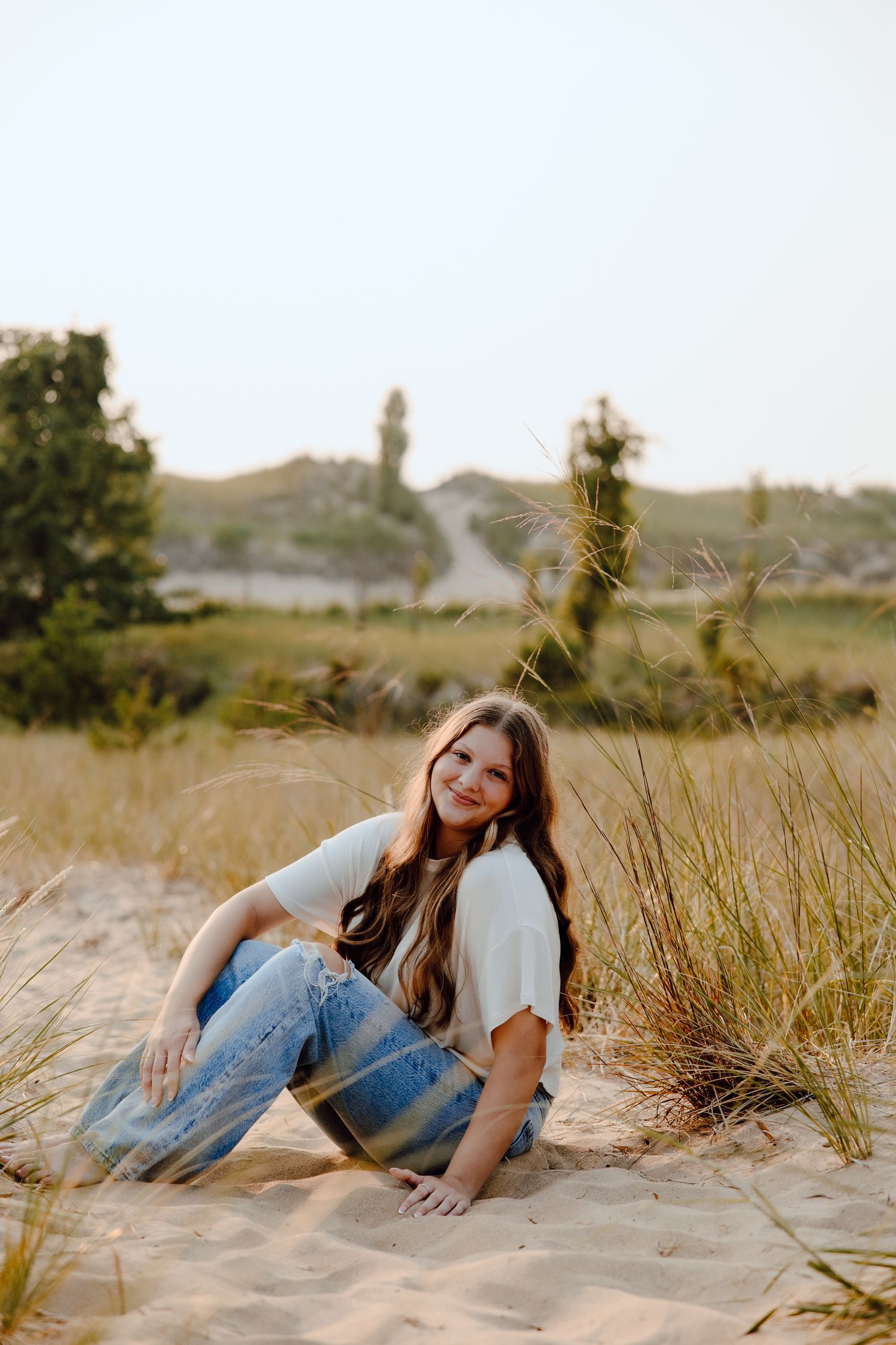 Portrait series in tall grass and sand dunes during golden hour lighting.