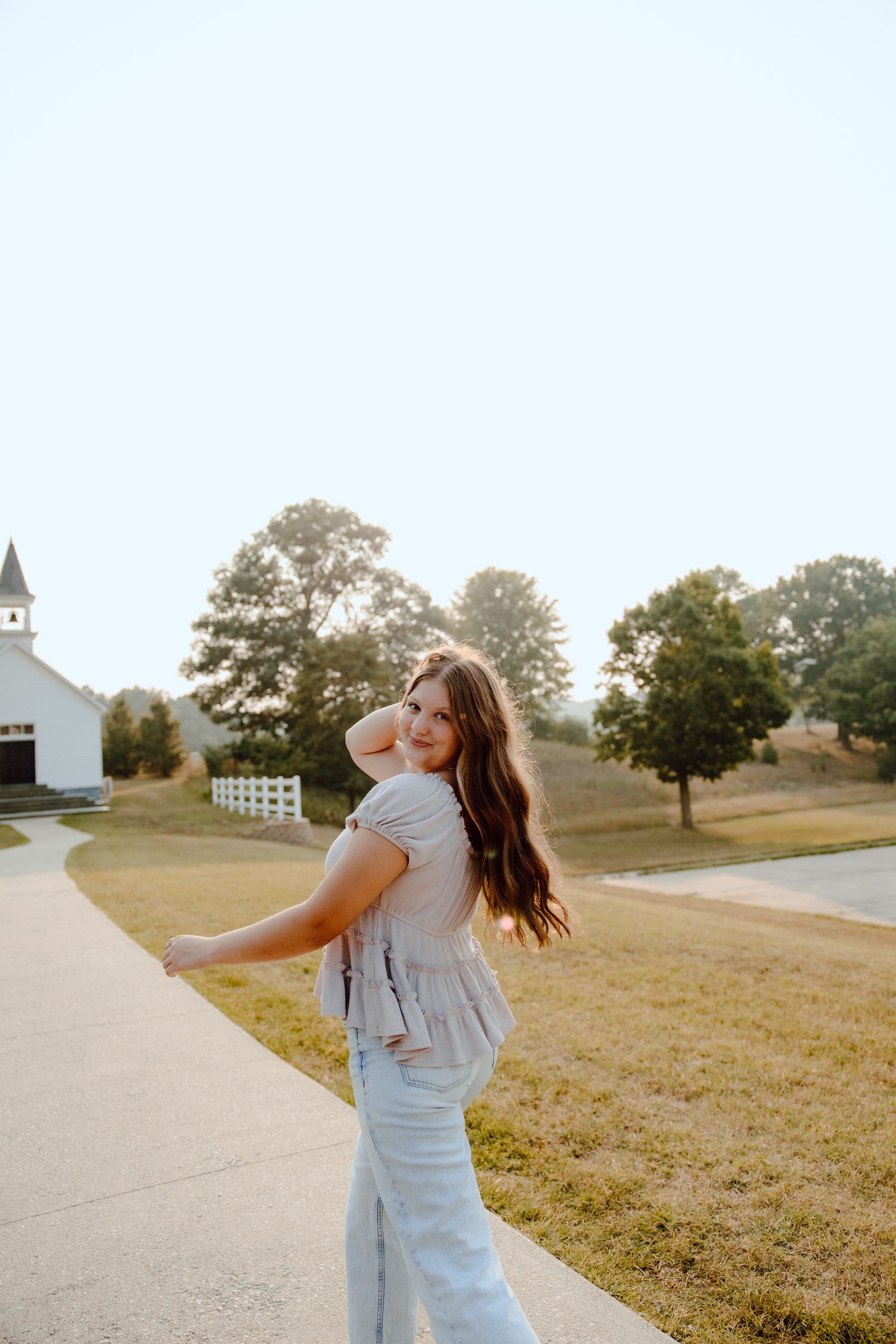 Portrait series on a path with a white church building visible in the background.