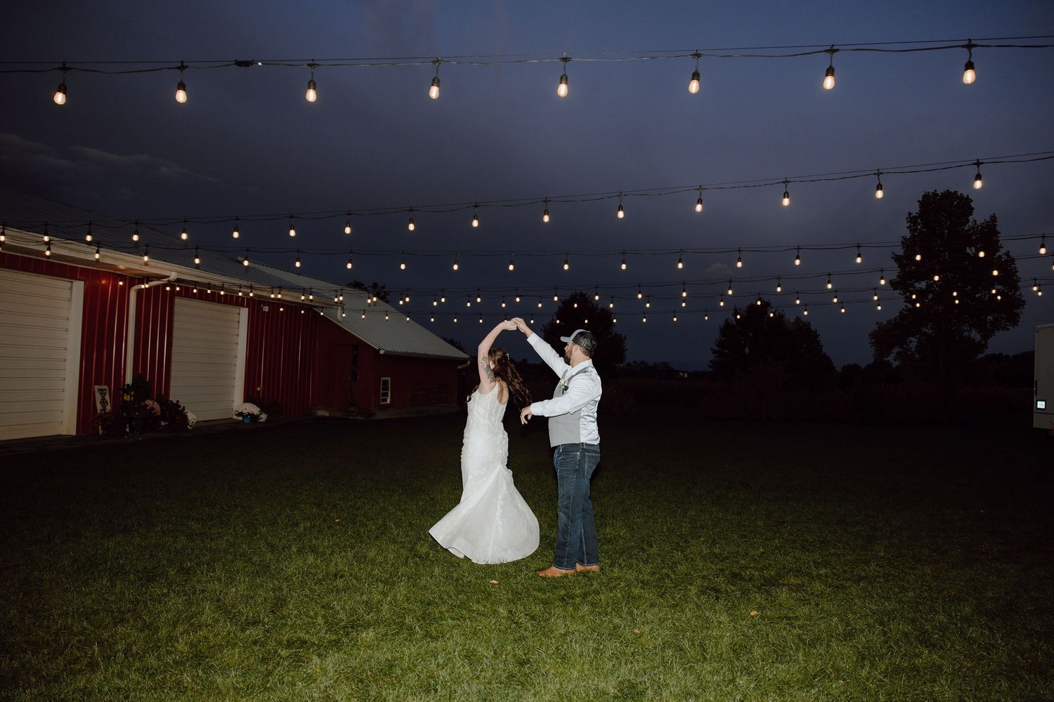 Outdoor string lights create a magical ambiance against a dark night sky.