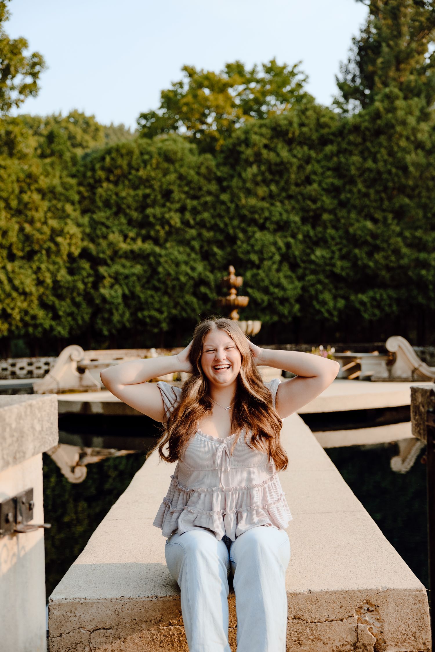 Casual outdoor portrait series on a concrete structure with trees in background.