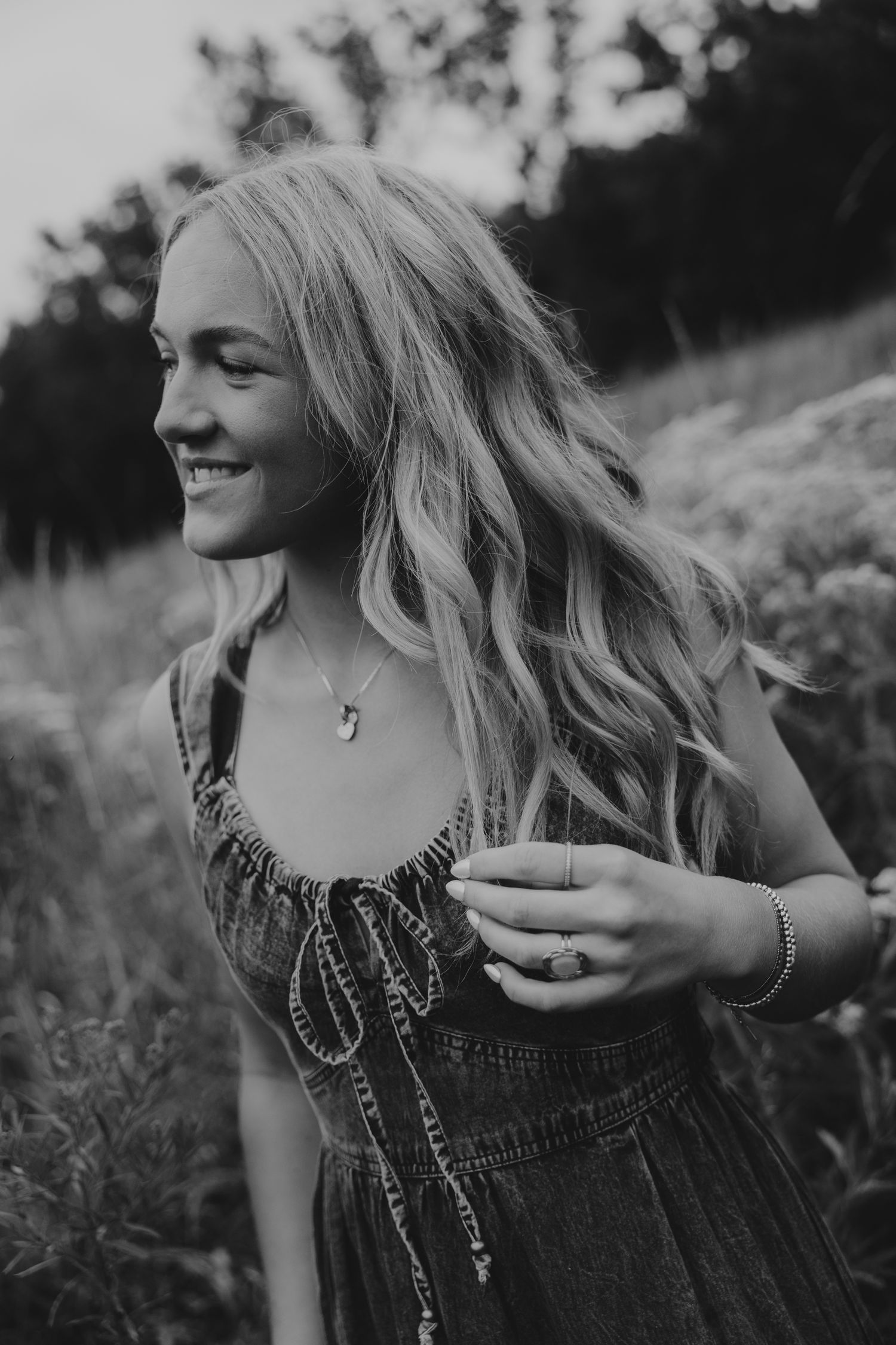 Black and white portrait of someone dancing in an embellished dress outdoors.