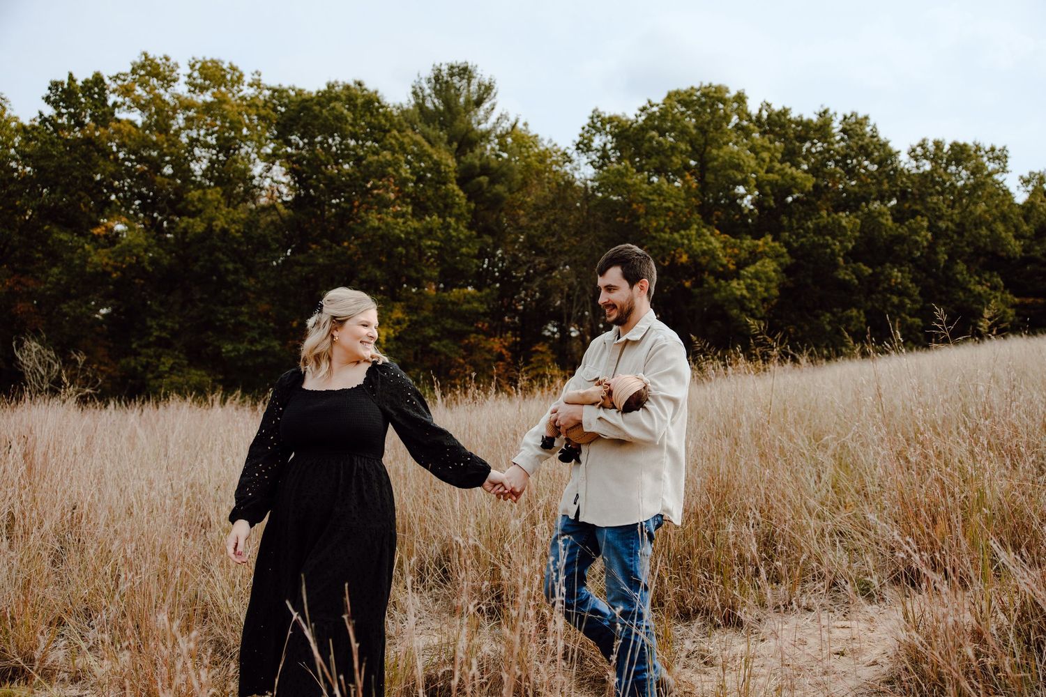 People interacting in a tall grass field during golden hour.