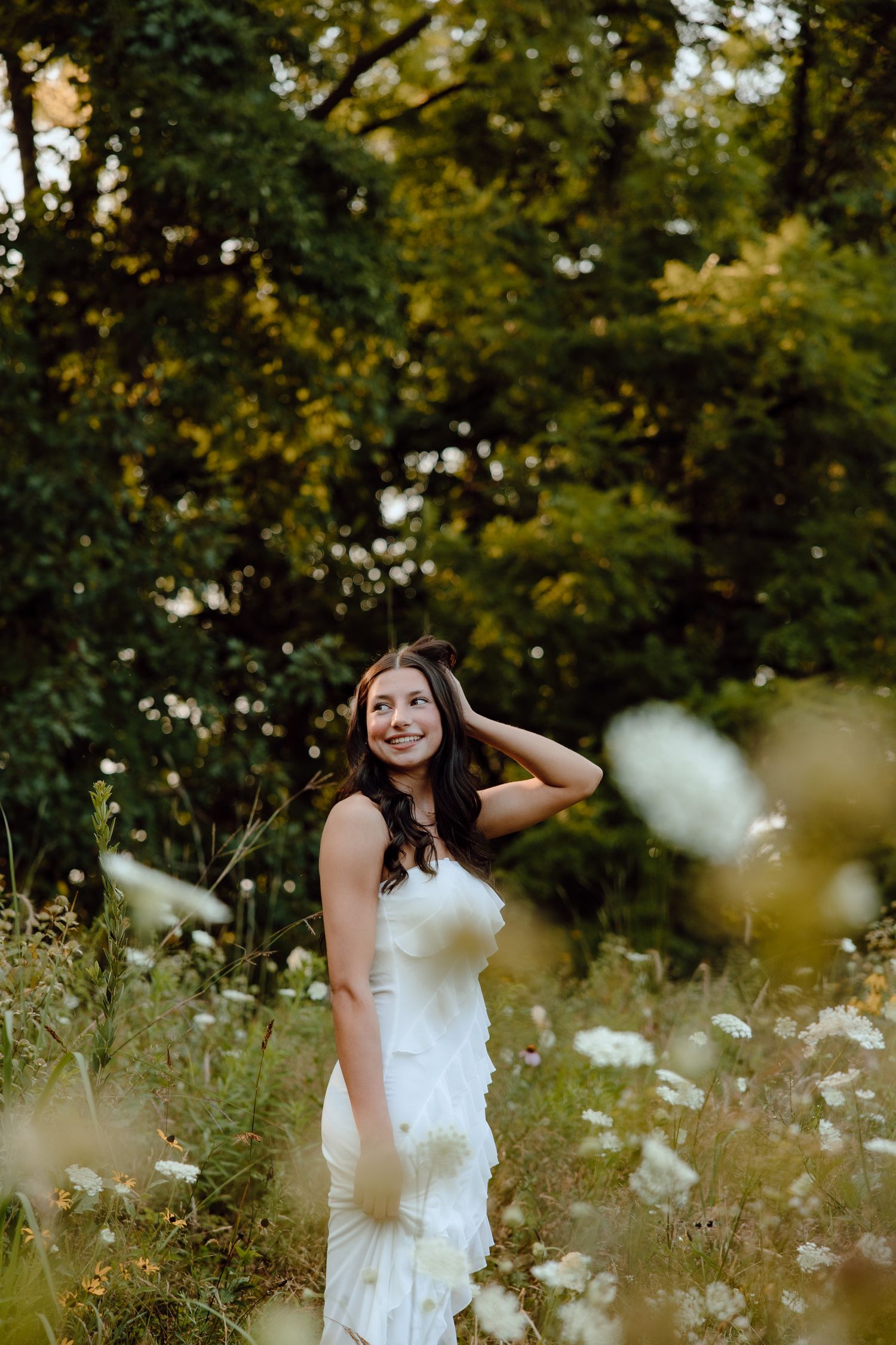 Portrait session in wildflower meadow with white daisies and natural summer lighting.