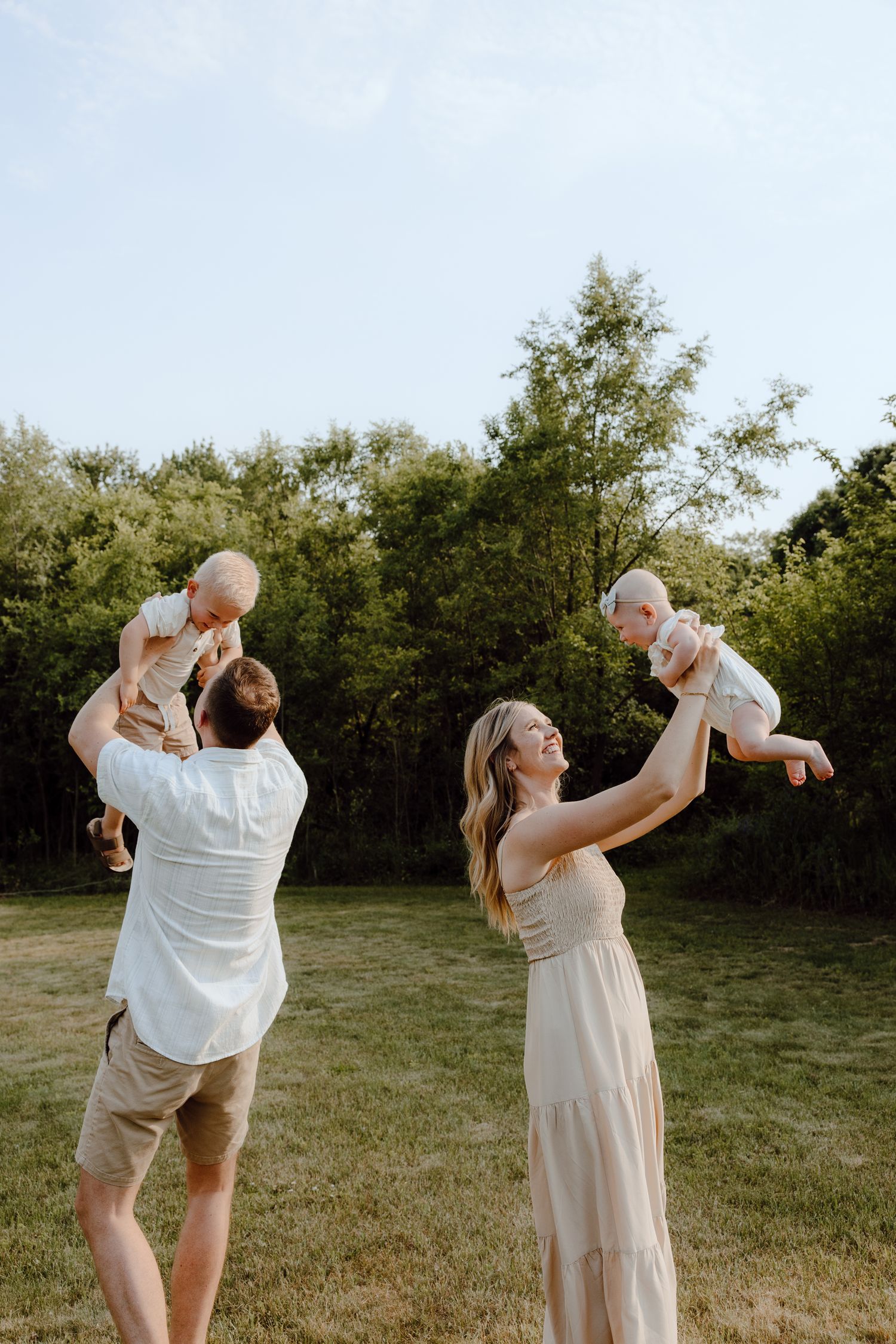 Series of photos capturing parents lifting and playing with their baby in a sunlit outdoor setting.