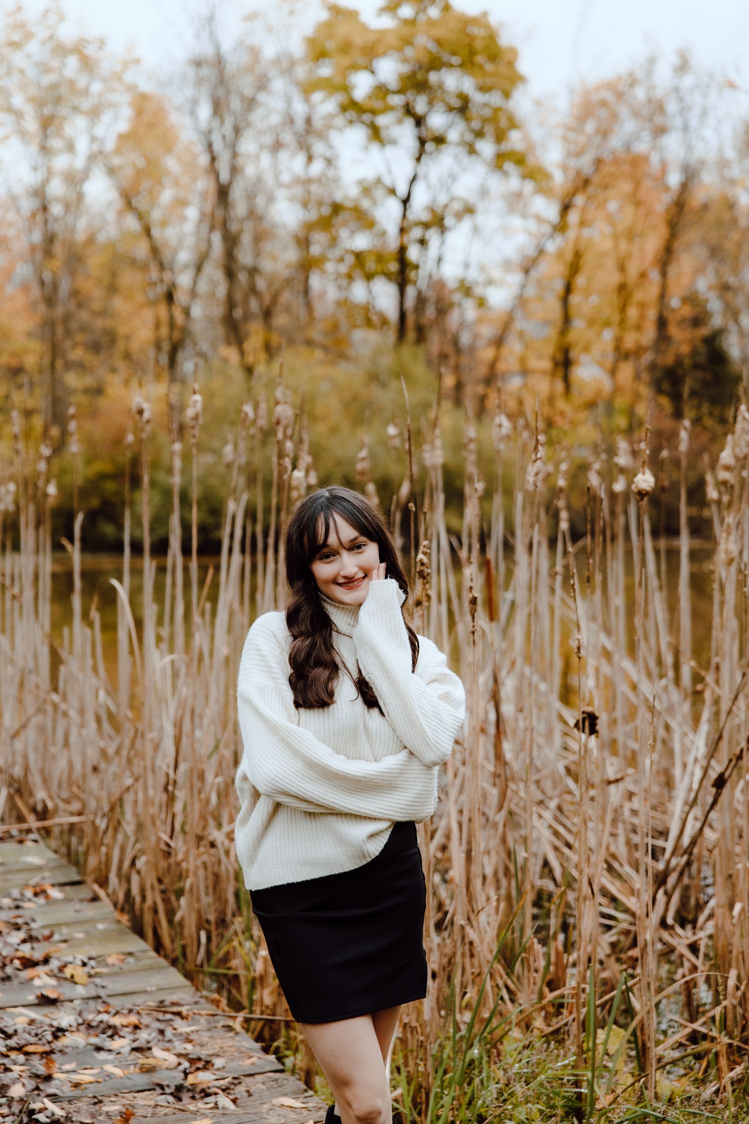 Candid moments captured among tall grass and fall trees wearing a white sweater.