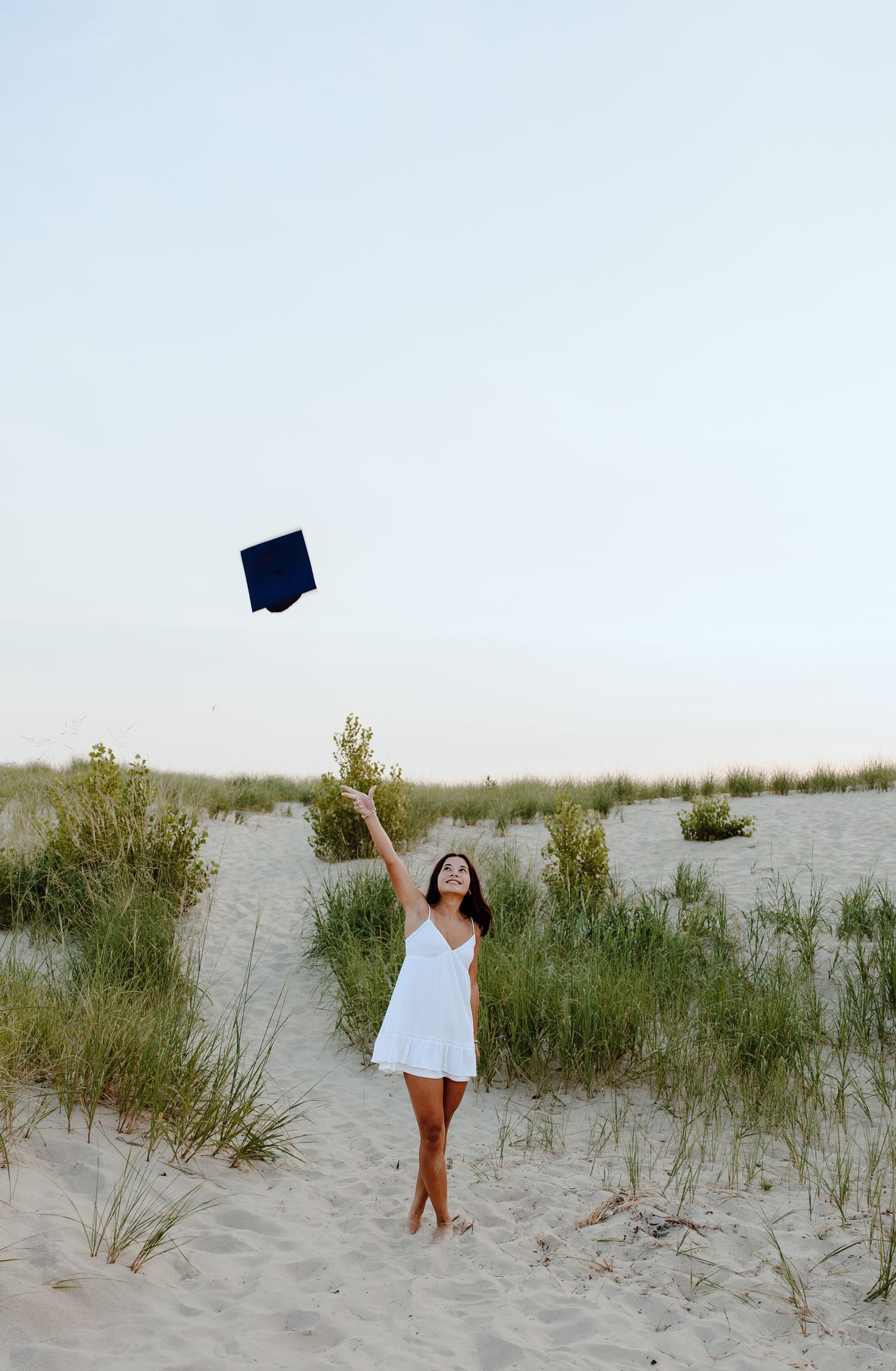 Artistic beach portrait sequence with white dress against coastal dunes.