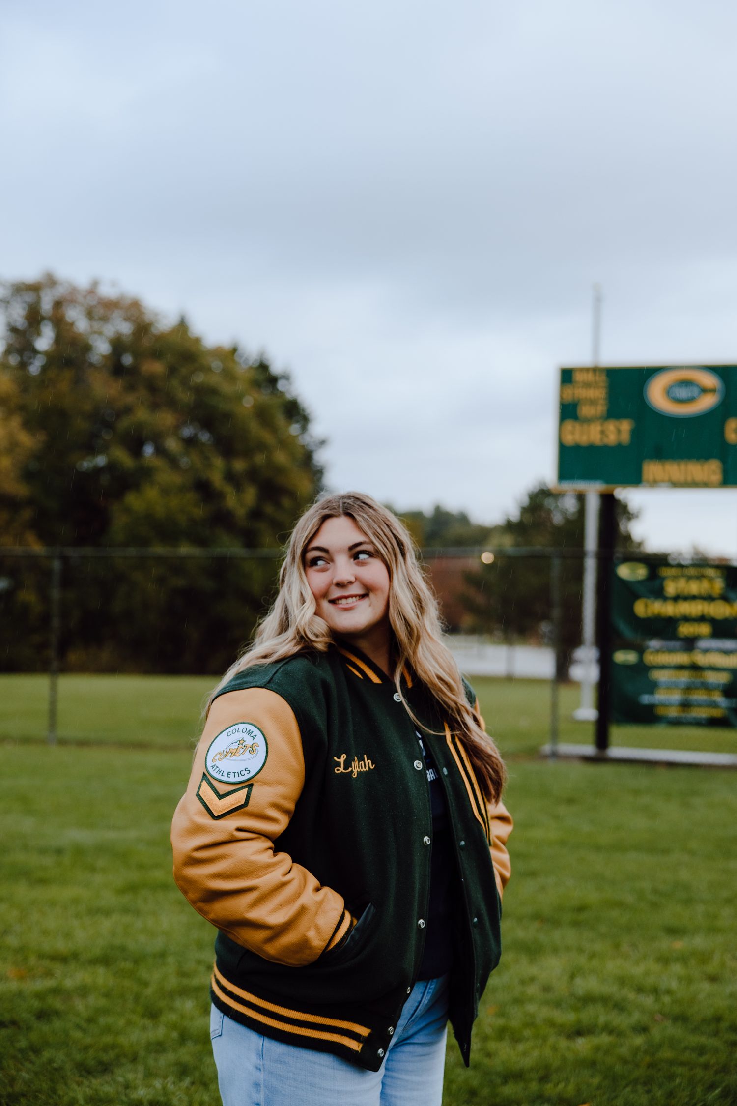 Letterman jacket photoshoot on a grassy field with sports equipment.