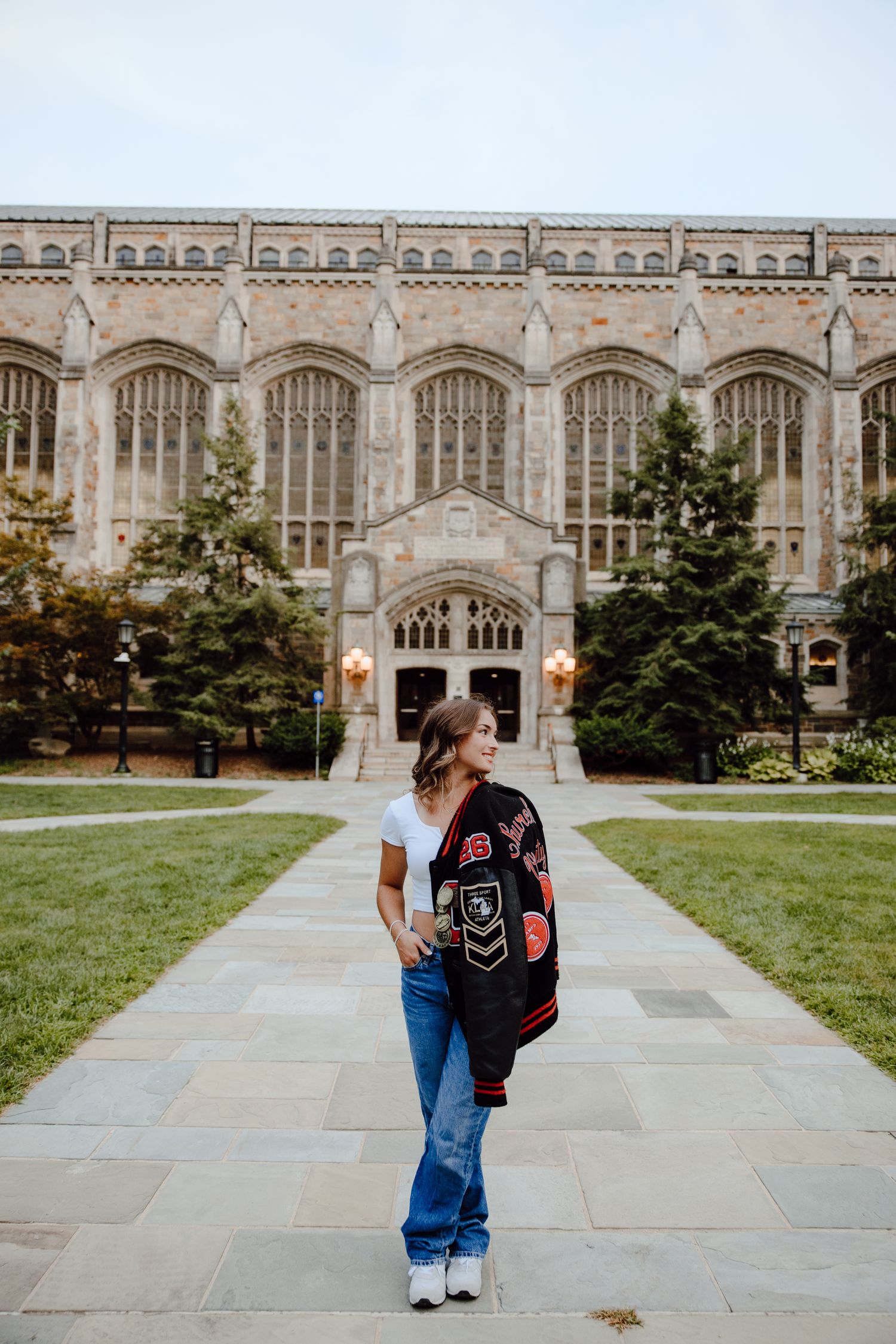 A person with a backpack walks away from a grand Gothic university building.