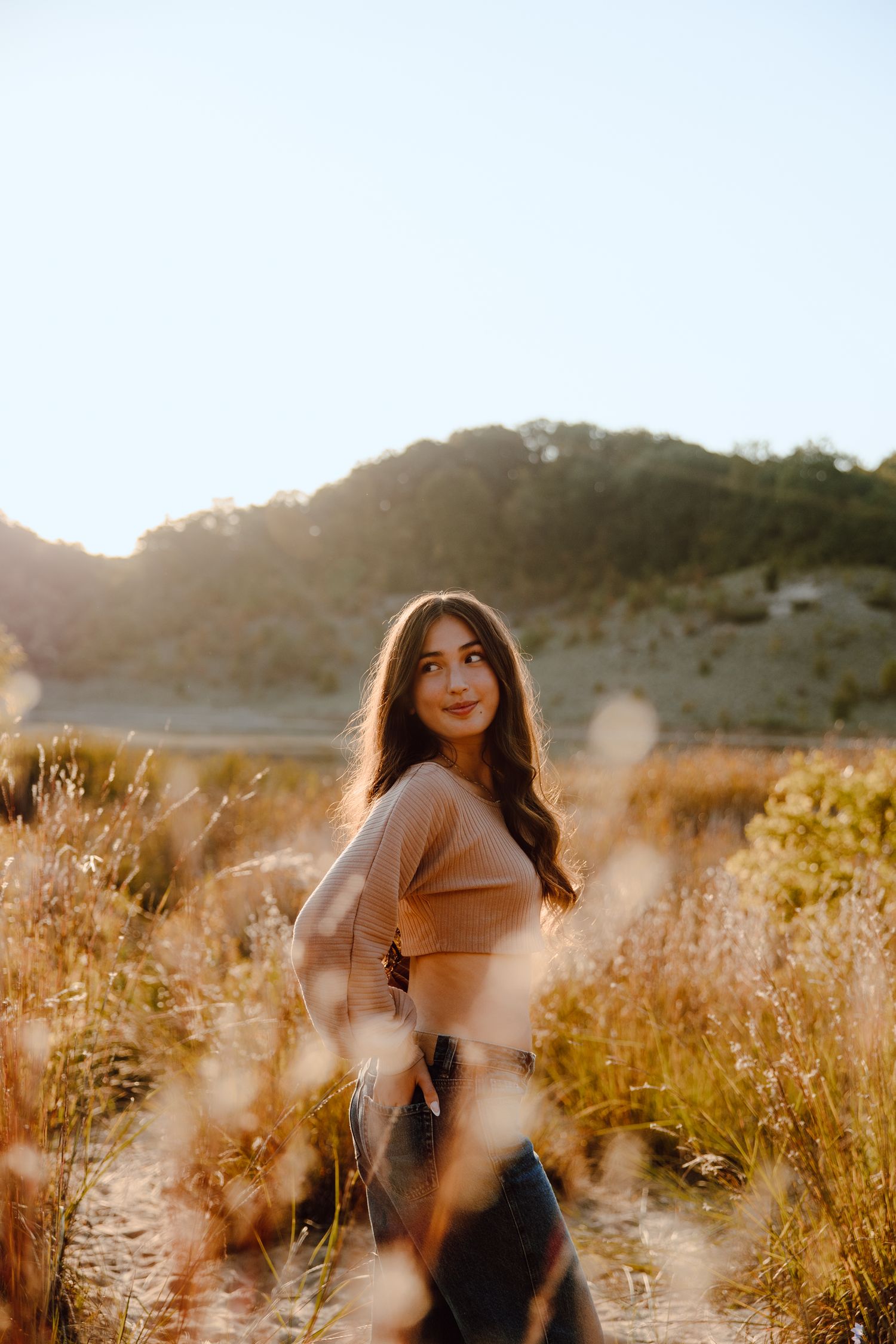 Candid sunset photoshoot in a field with warm autumn colors and natural lighting.