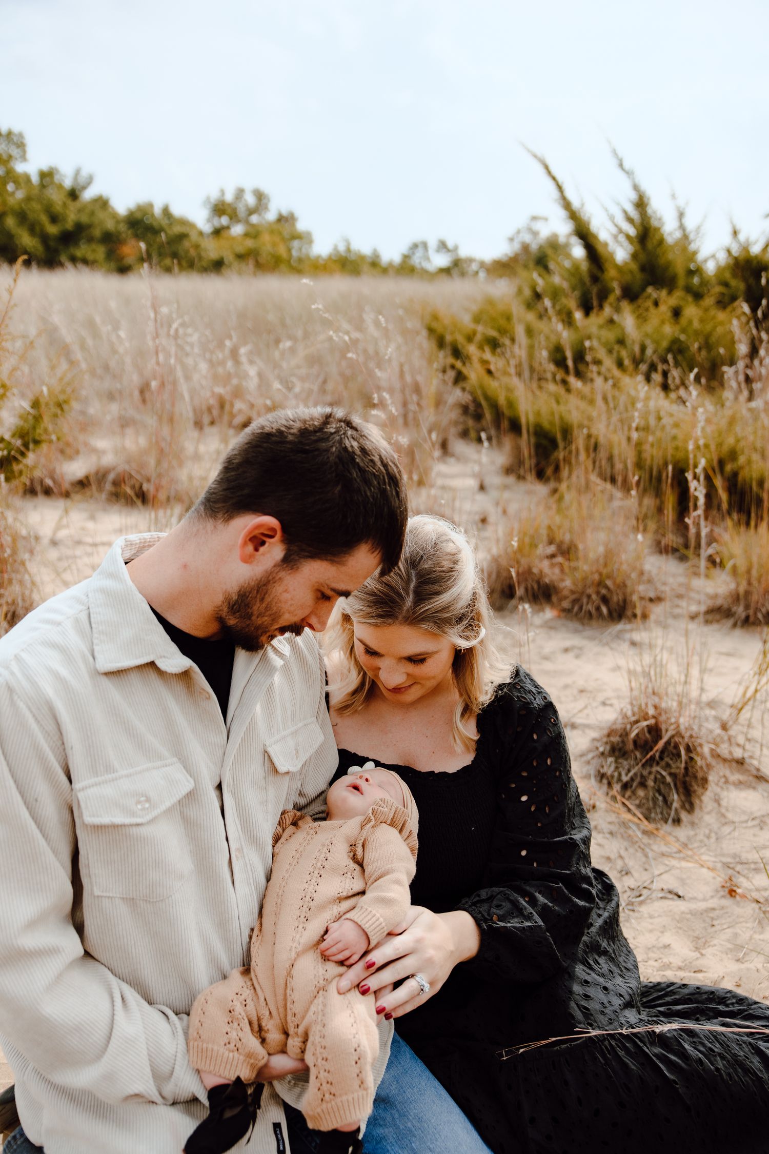 Family sharing intimate moment outdoors in golden natural setting.