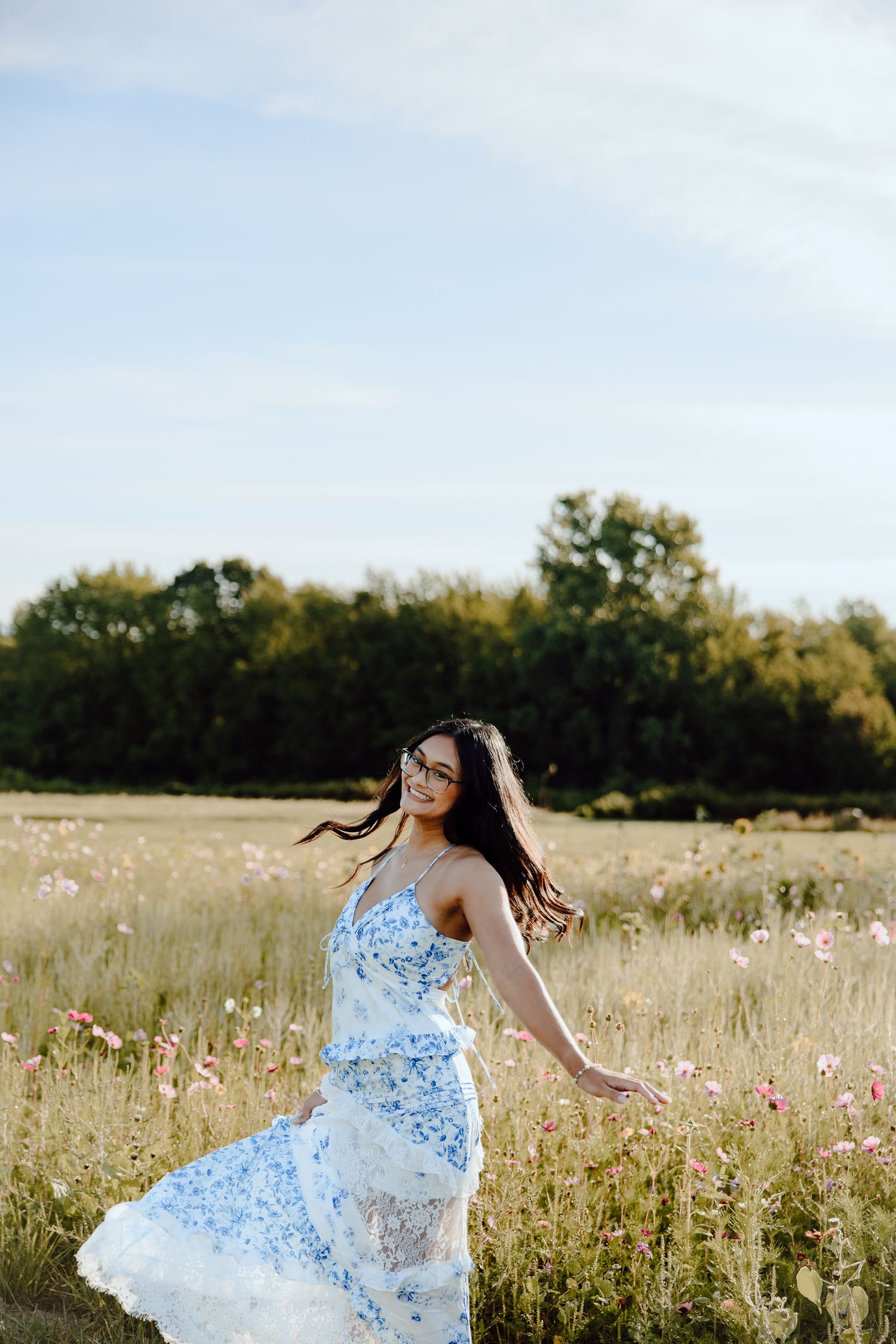 A flowing blue dress twirls through a wildflower meadow on a bright summer day.