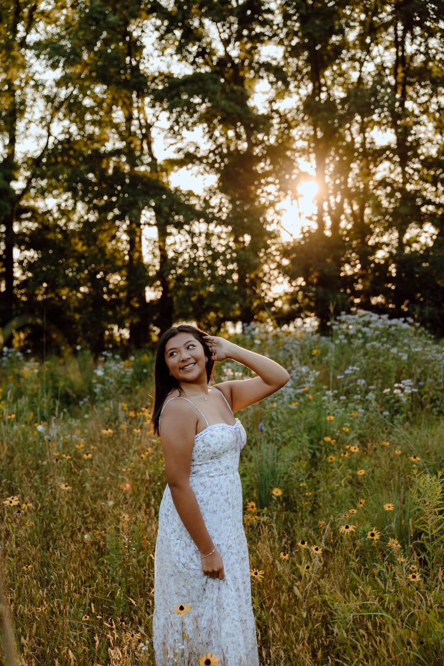 A white lace dress contrasts beautifully with wildflowers during golden hour.