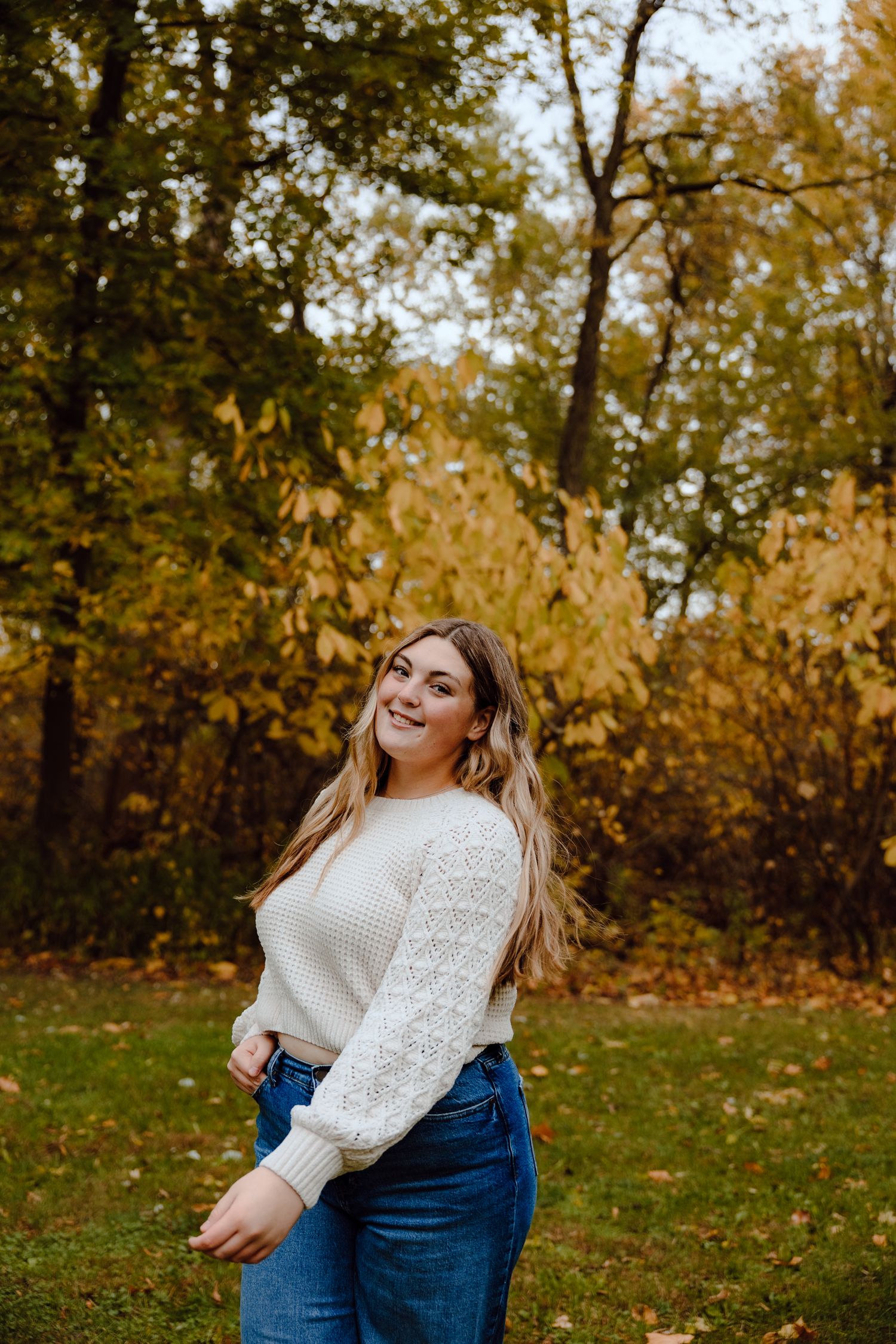 Candid outdoor portraits with white sweater against golden fall foliage.