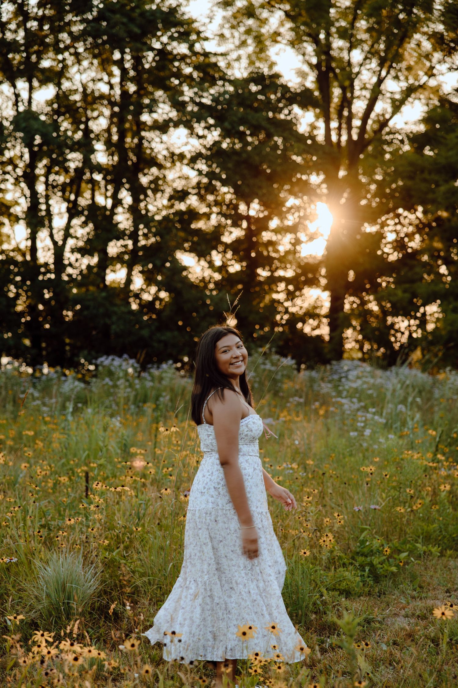 Dancing and twirling in a white dress during sunset in a wildflower field.