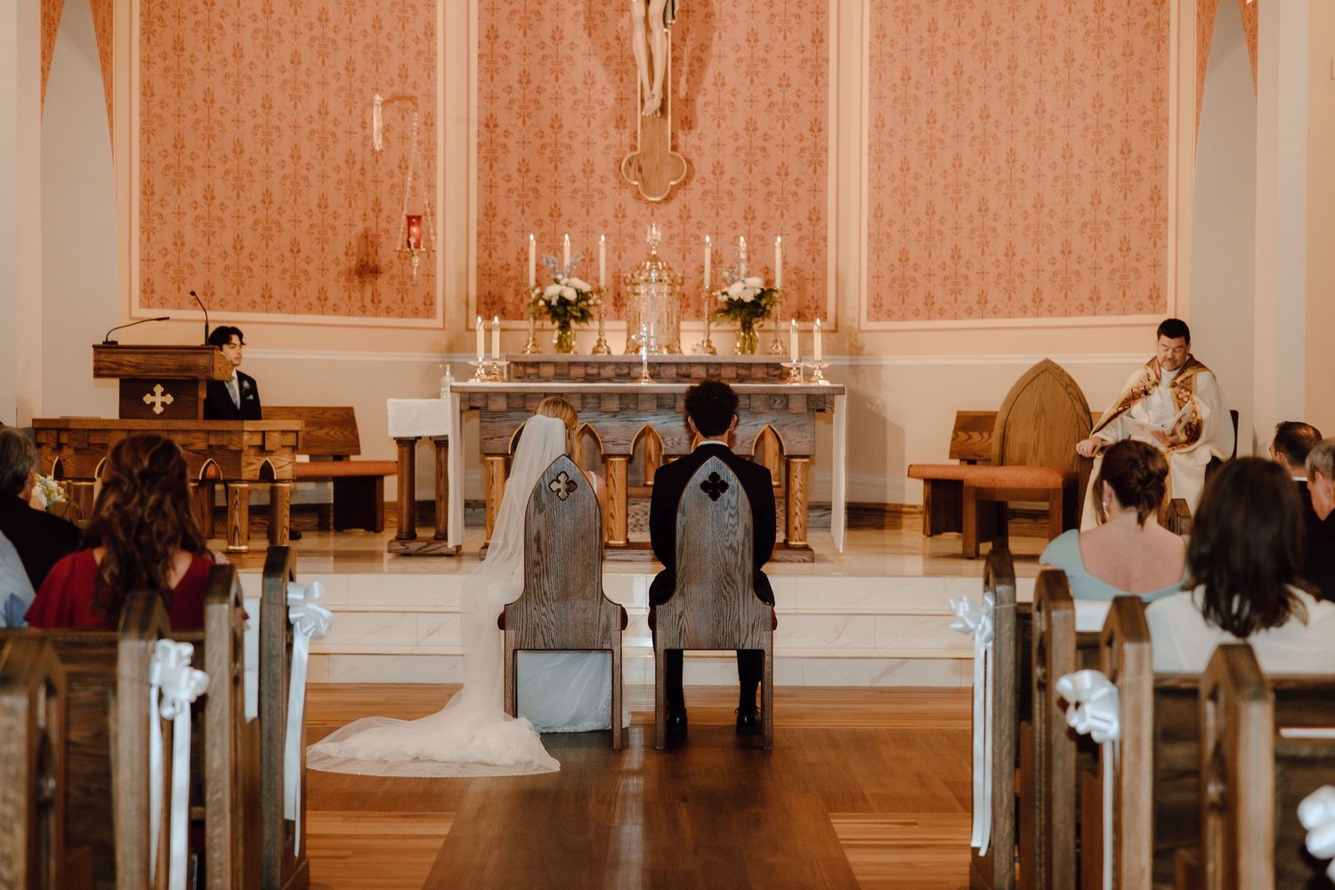 Bride and groom kneeling at altar during traditional Catholic church wedding ceremony.