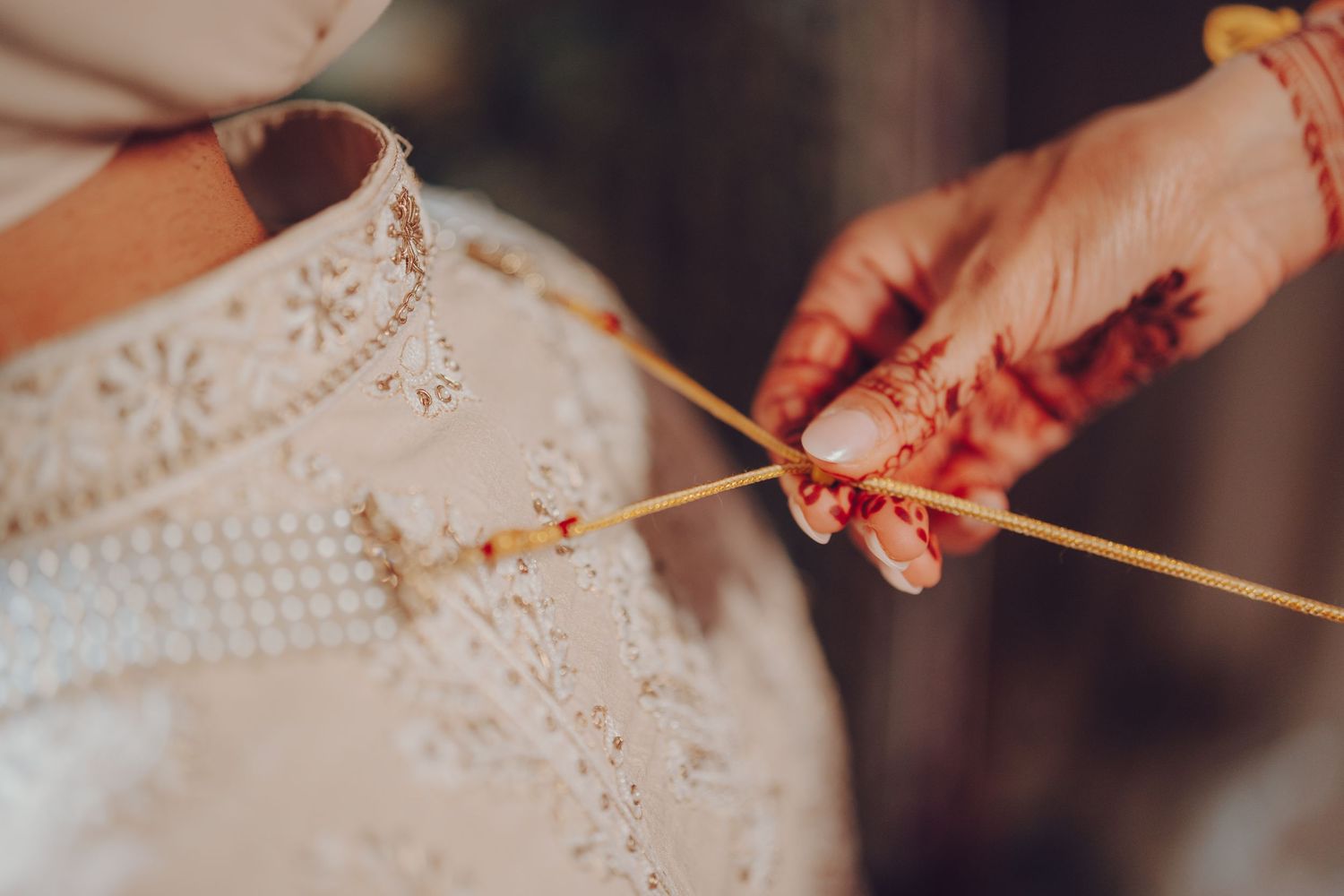 Hands holding chopsticks reach across a dining table to share food during a communal meal.