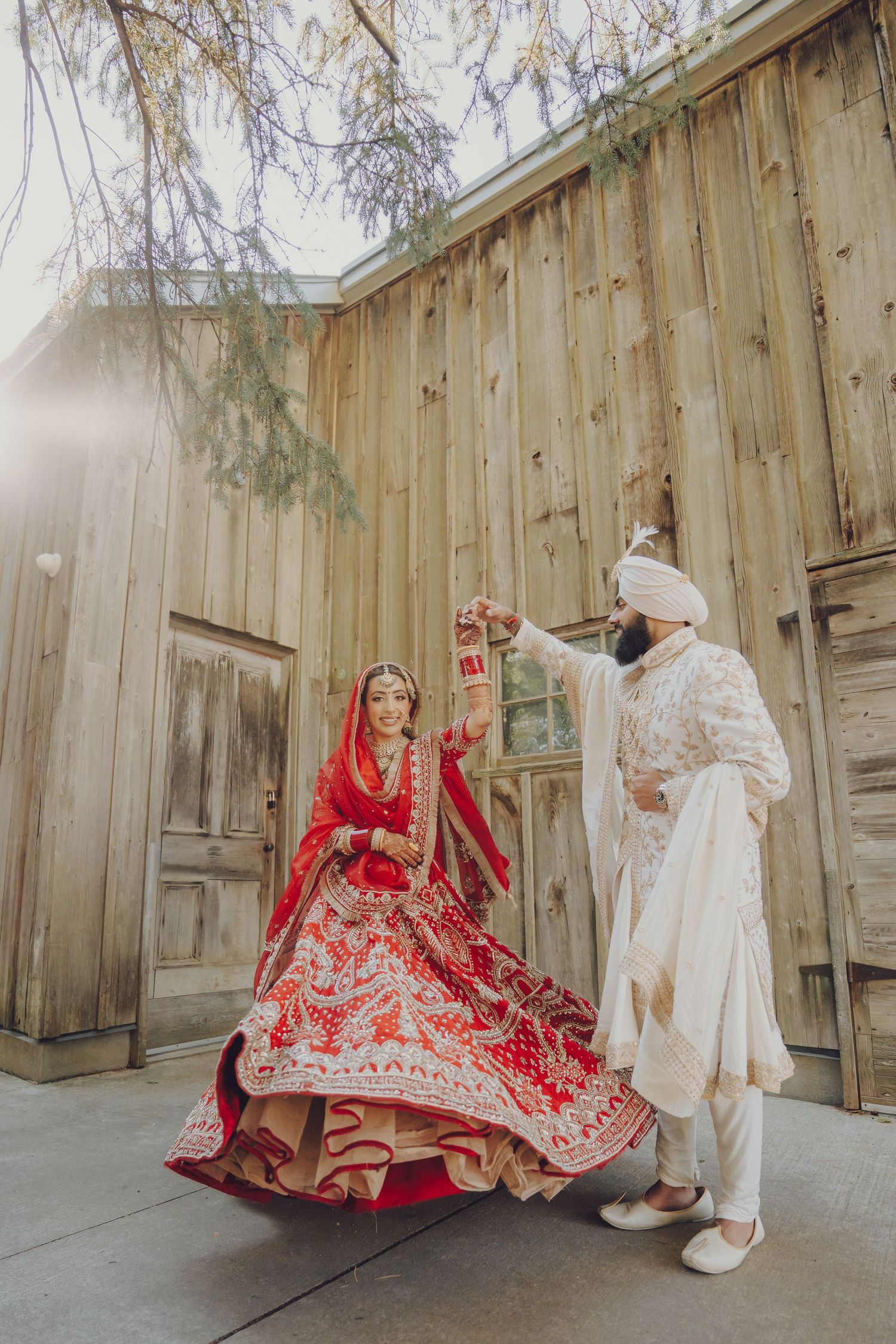 A couple in traditional South Asian wedding attire pose against a rustic wooden wall in a series of candid moments.