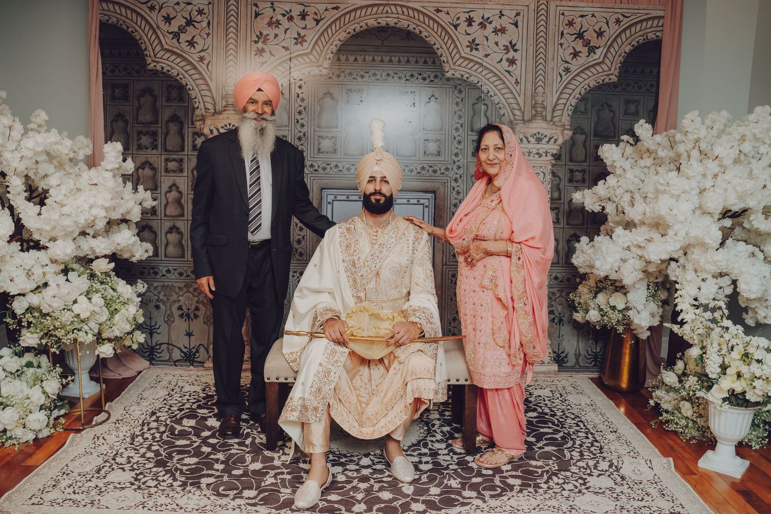 Elegant wedding celebration in ornate venue with traditional decor and white floral arrangements.