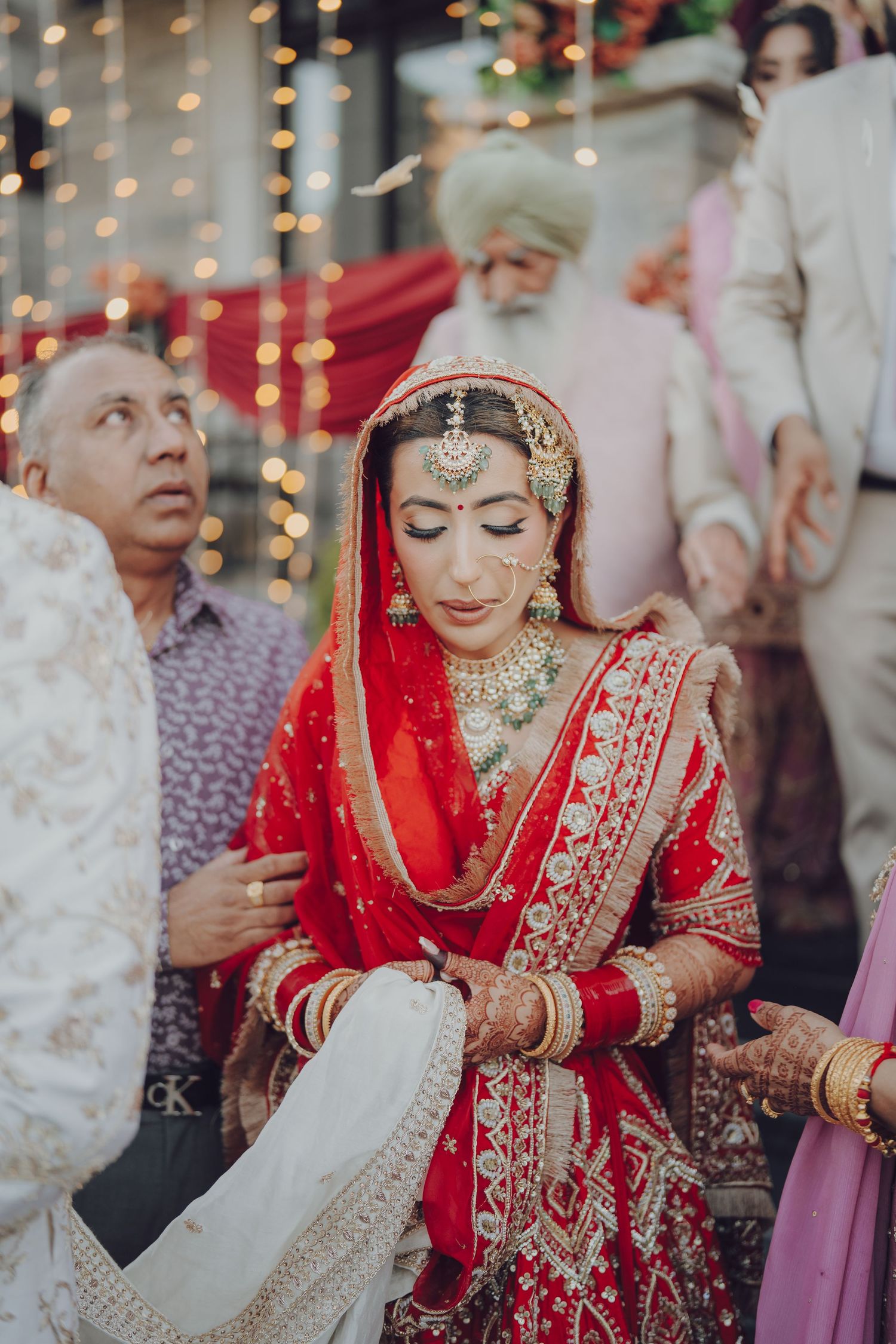 Traditional Indian wedding ceremony with bride in red lehenga and ornate jewelry.