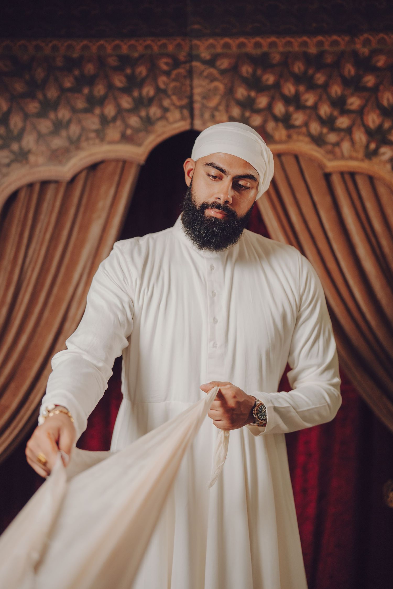 Person in white traditional dress and turban shown in a sequence of movement shots.