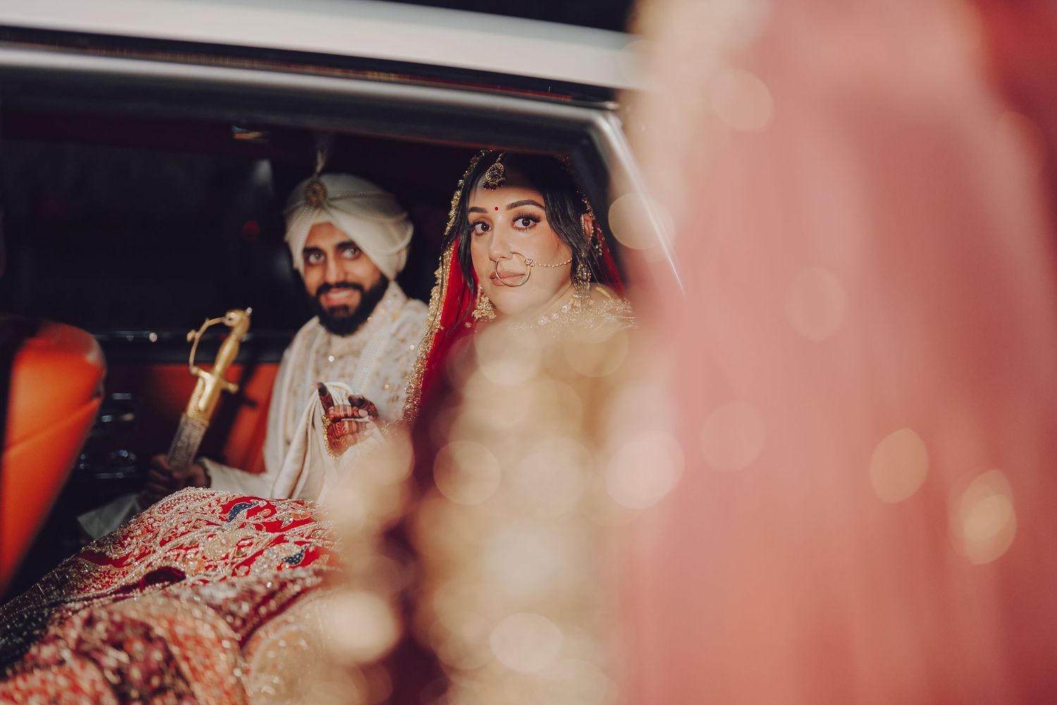 Candid moments captured during an Indian wedding reception with soft bokeh lighting effects.