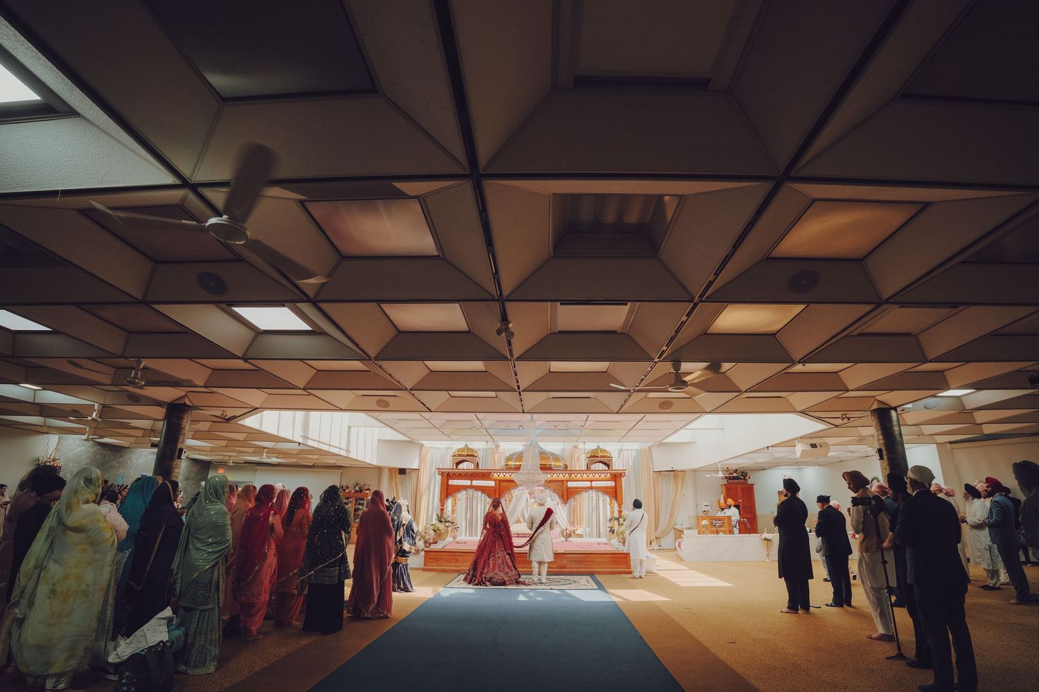 Long indoor corridor with fluorescent lighting and ceiling panels.