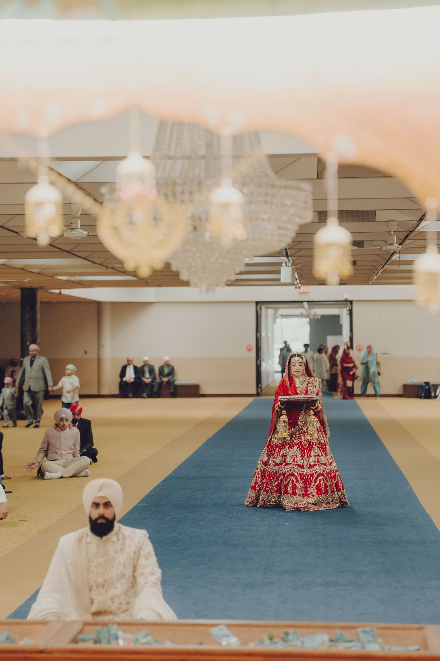 Panoramic view of wedding ceremony in progress with blue carpet and decorative ceiling.