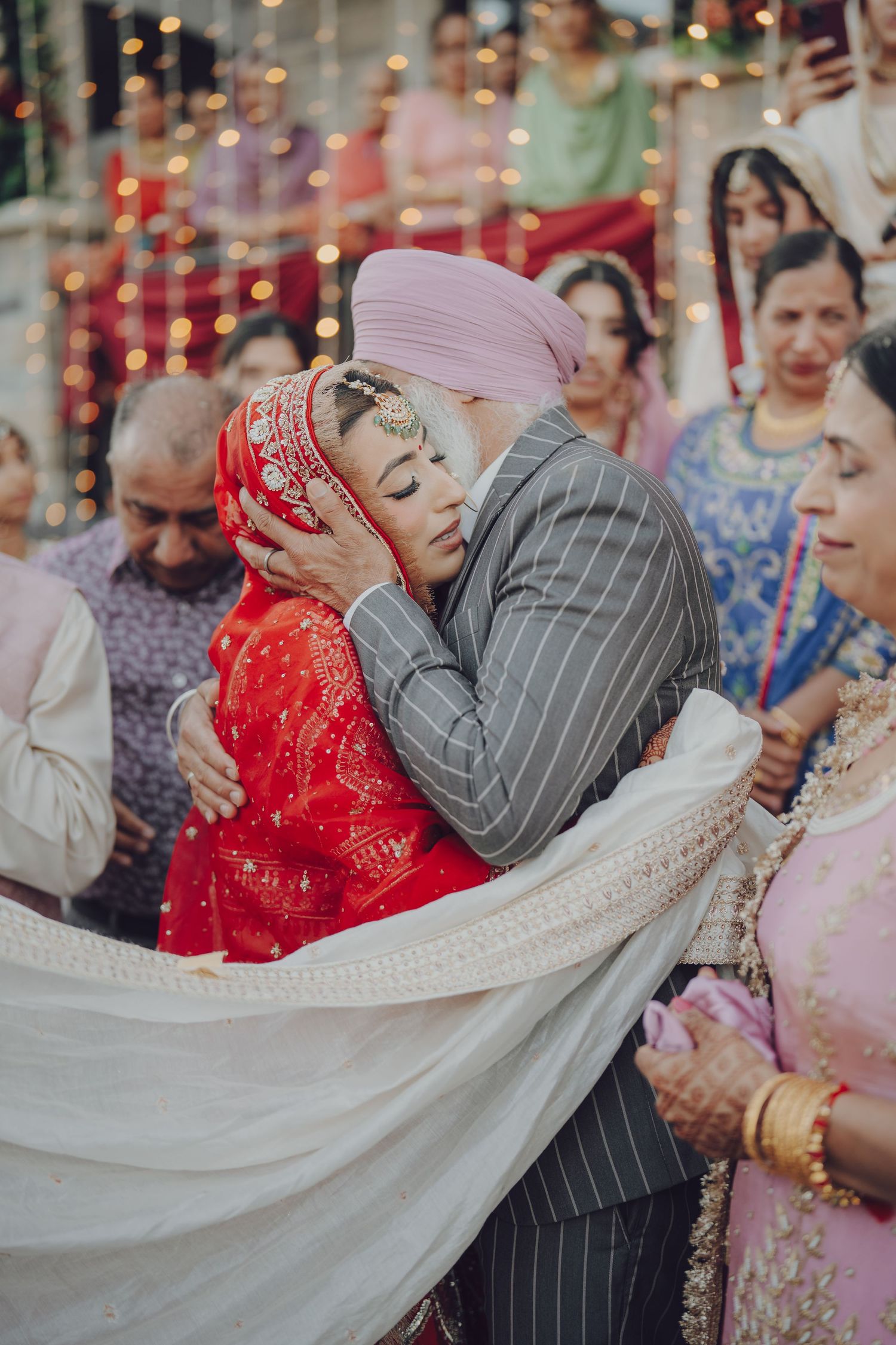 Emotional moment during Indian wedding ceremony with family members embracing.