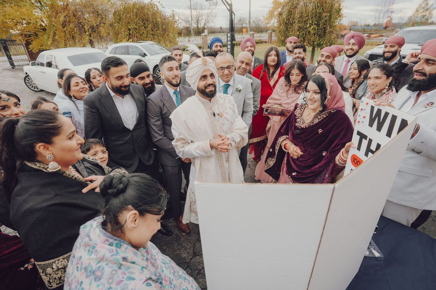 Large group of wedding guests gathered outside for cultural celebration.