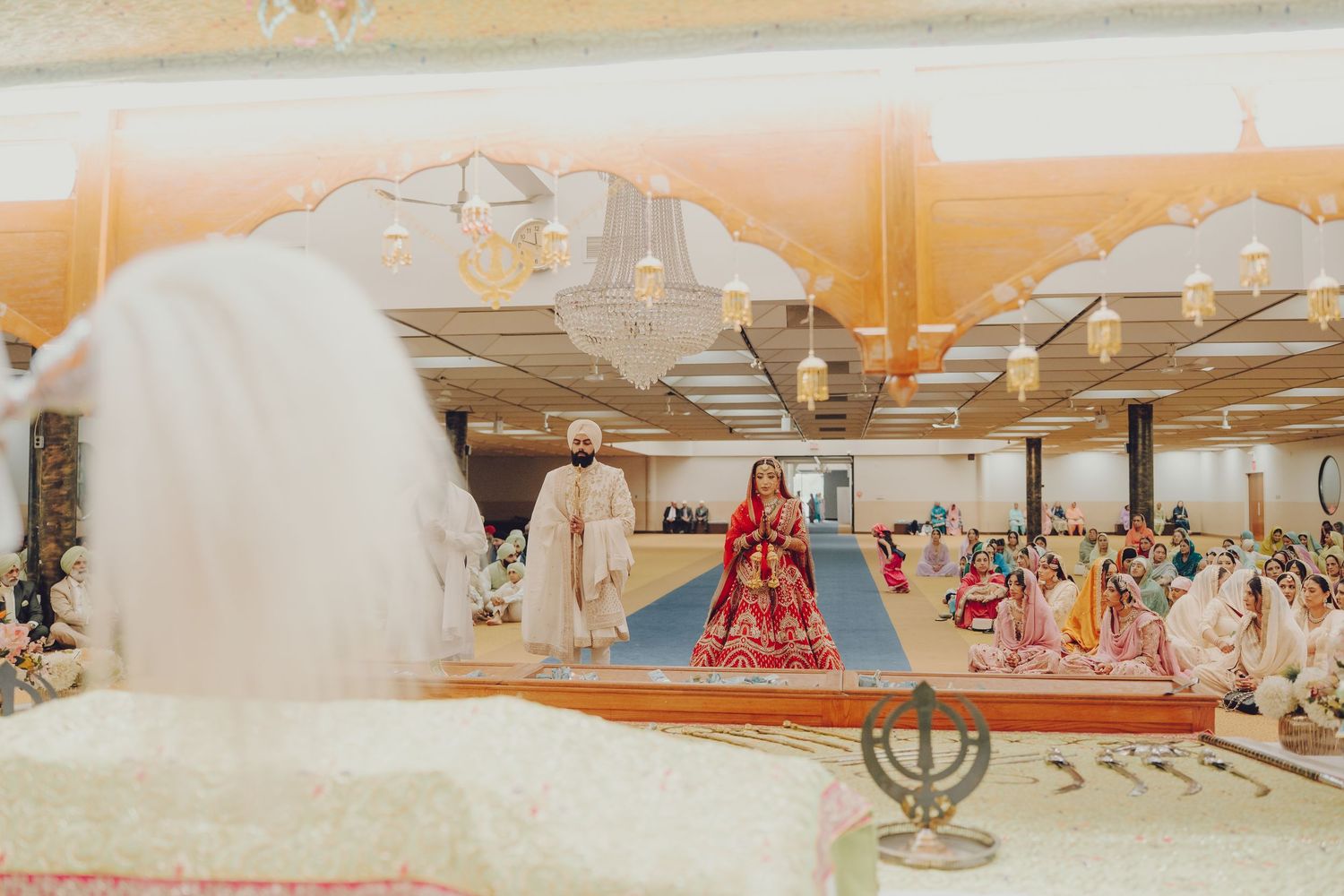 Wide angle shot of wedding venue interior with modern lighting and blue carpeted aisle.