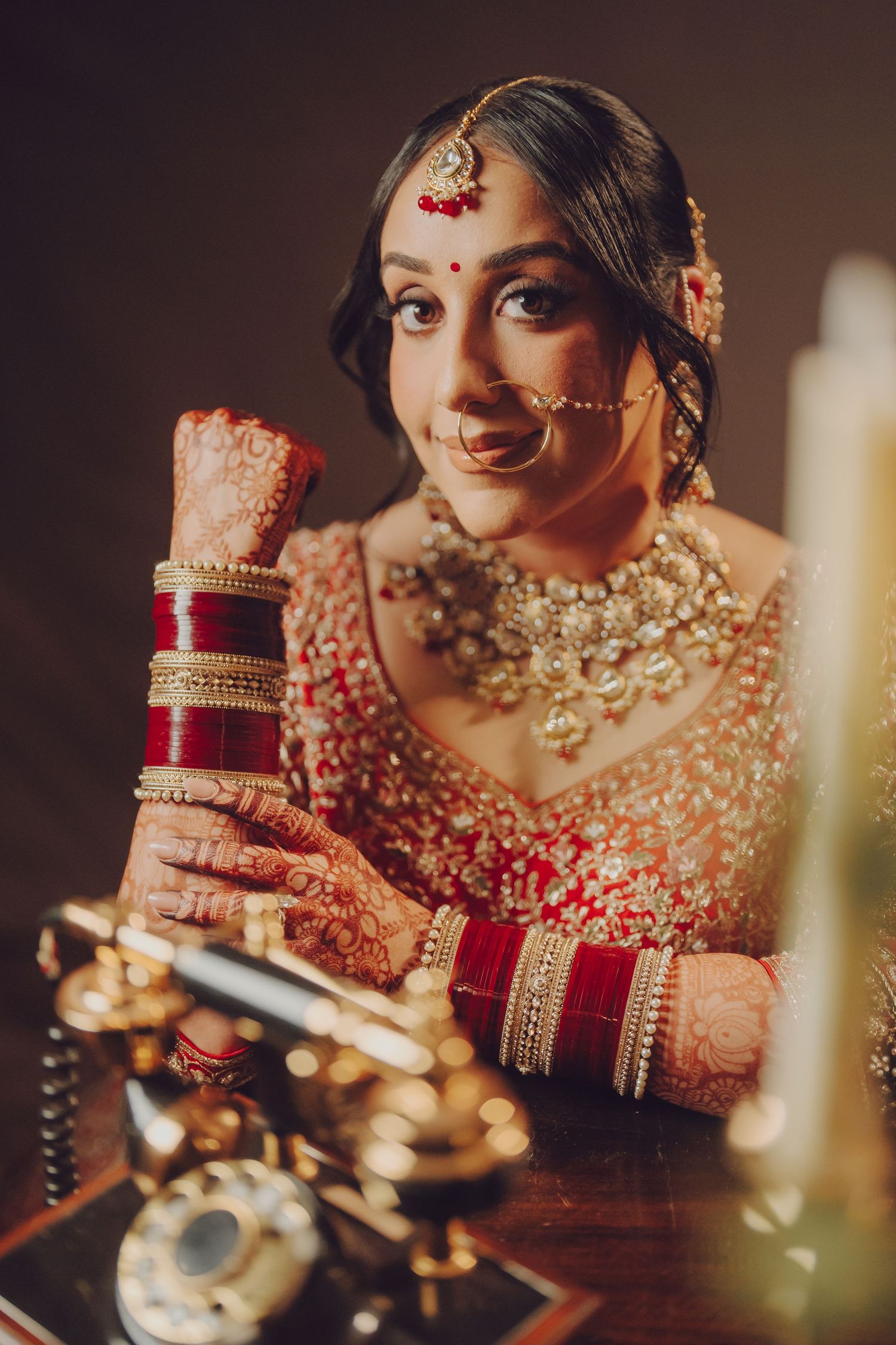 Close-up of traditional Indian bridal jewelry and accessories in warm lighting.